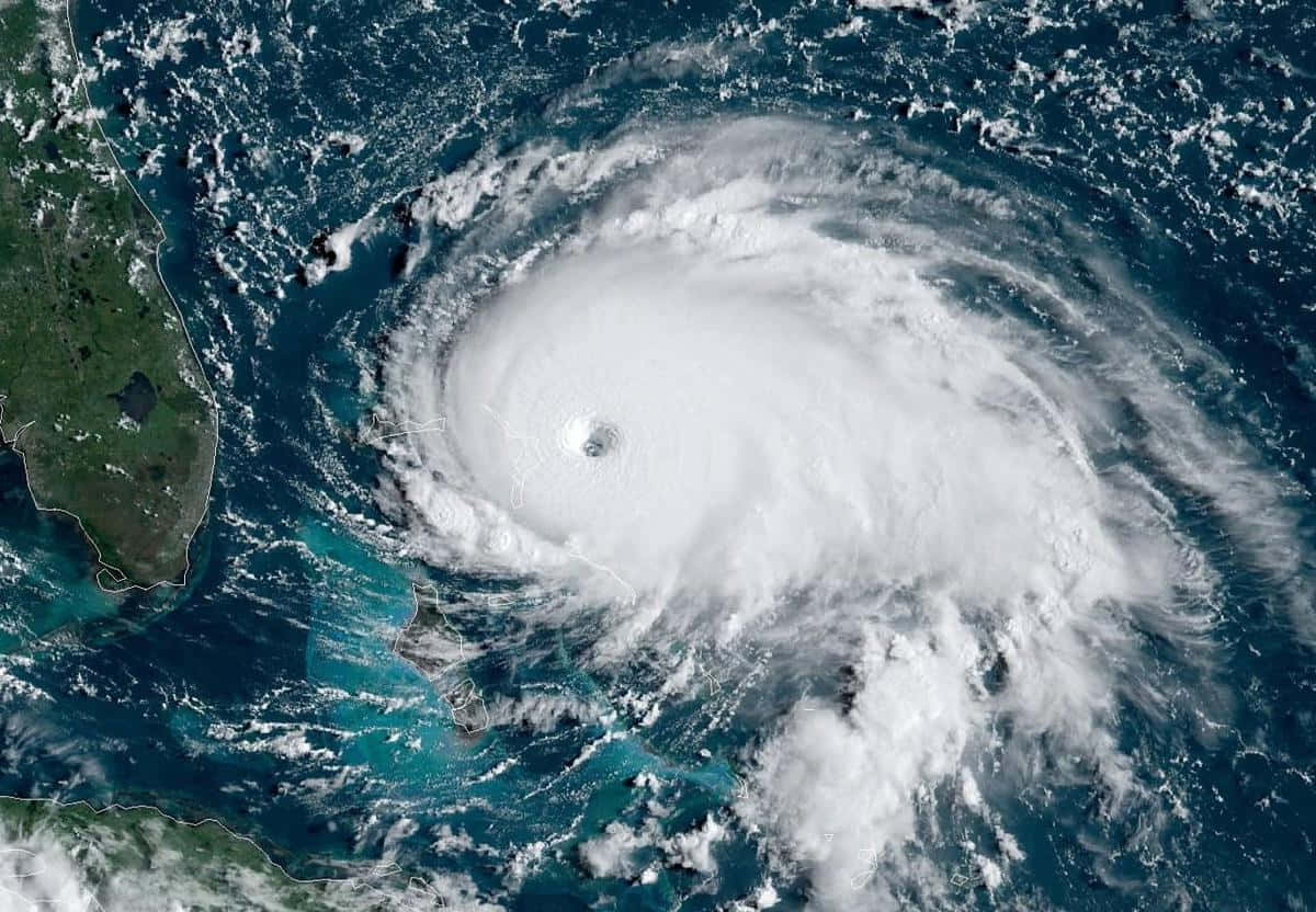 「自然的無可抗拒之力」 壁紙 — 一個巨大嘅颶風，帶有清晰嘅風眼，喺佛羅里達附近嘅深藍色海洋上空旋轉。