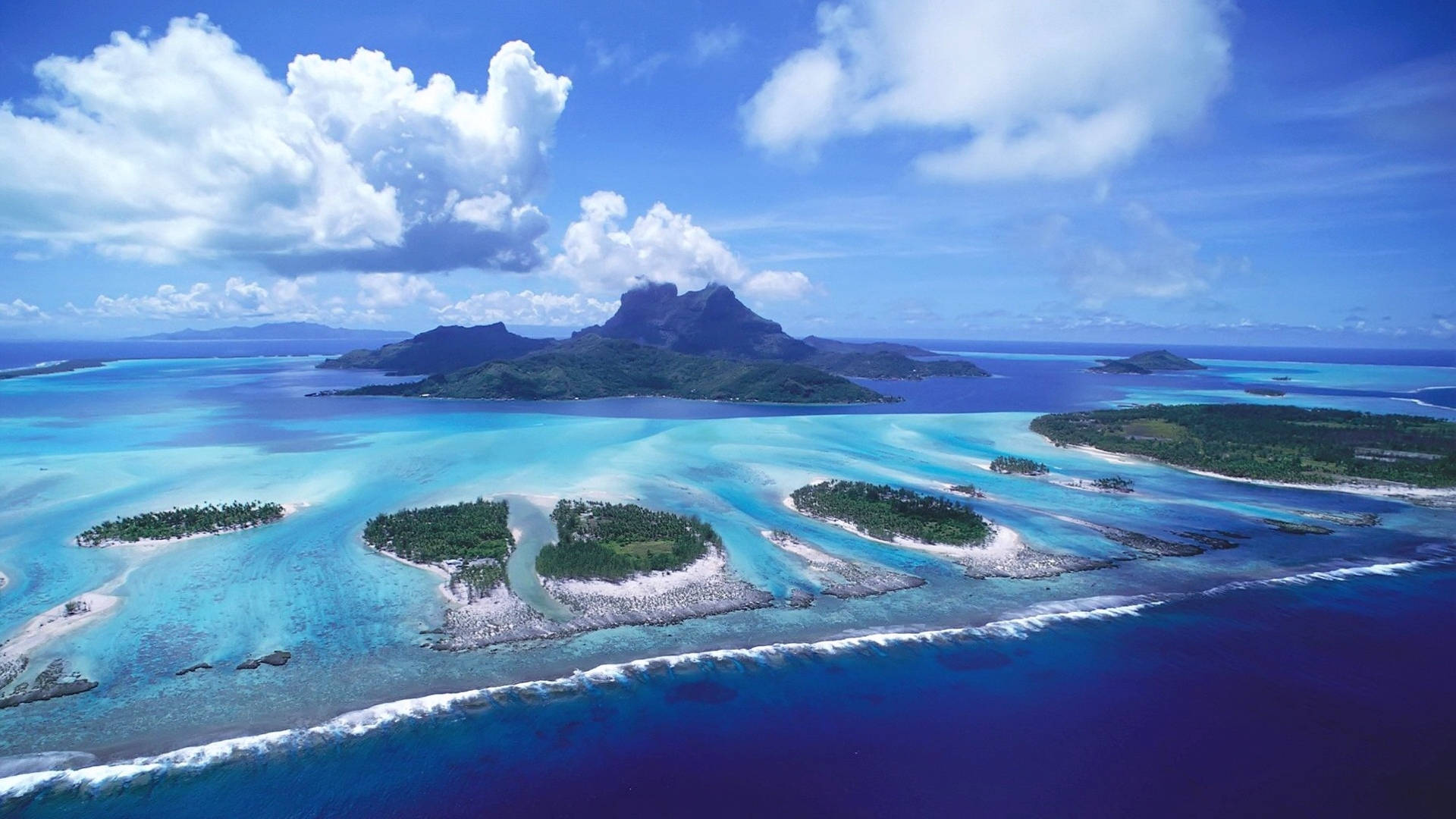藍天下，擁有碧綠色潟湖和白色沙灘的熱帶島嶼。 — 海景 壁紙