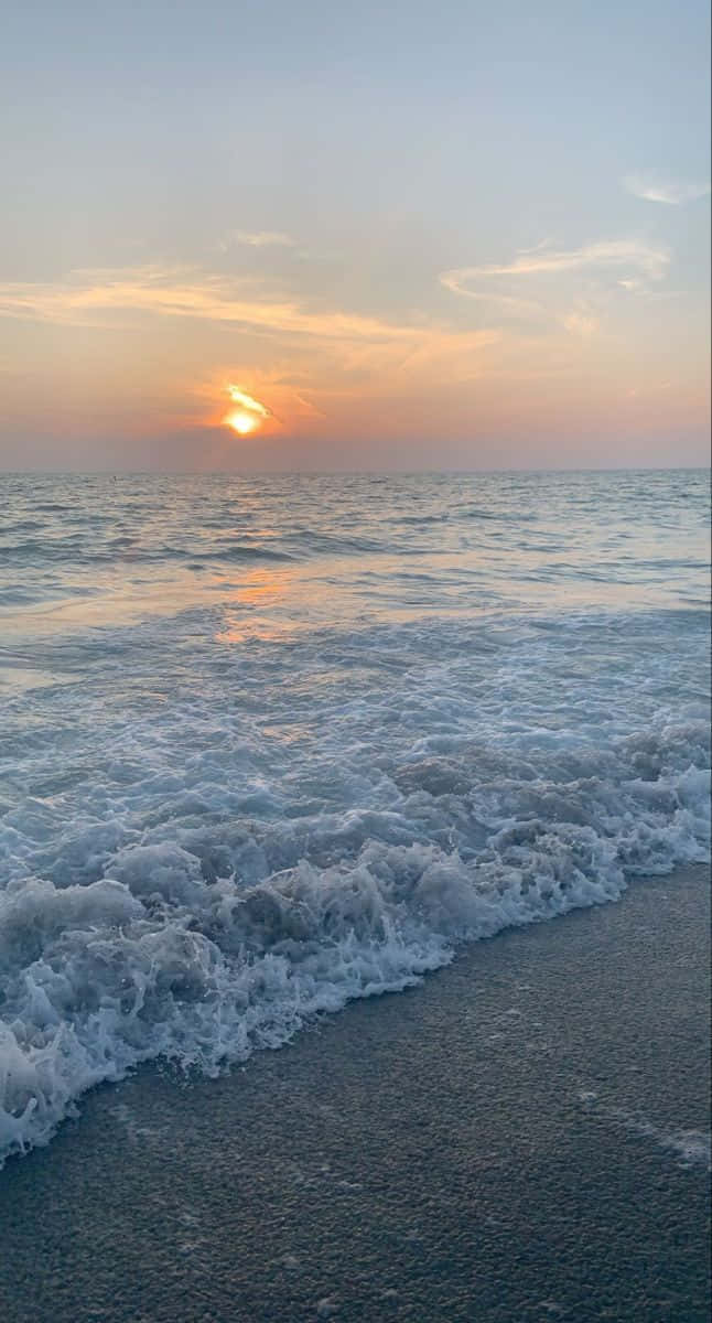 海洋上的夕陽，海浪湧向沙灘