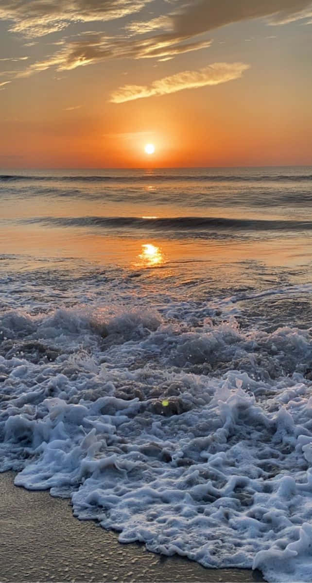 夕陽下的海洋，海浪拍打沙灘