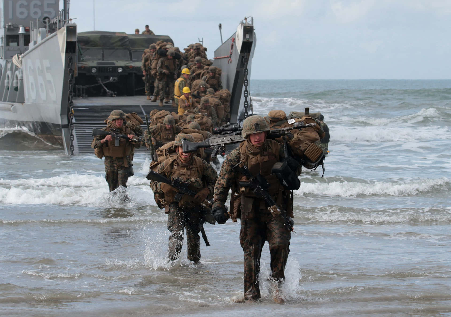 全副武裝的海軍陸戰隊員在海灘行動期間從登陸艇涉水上岸。