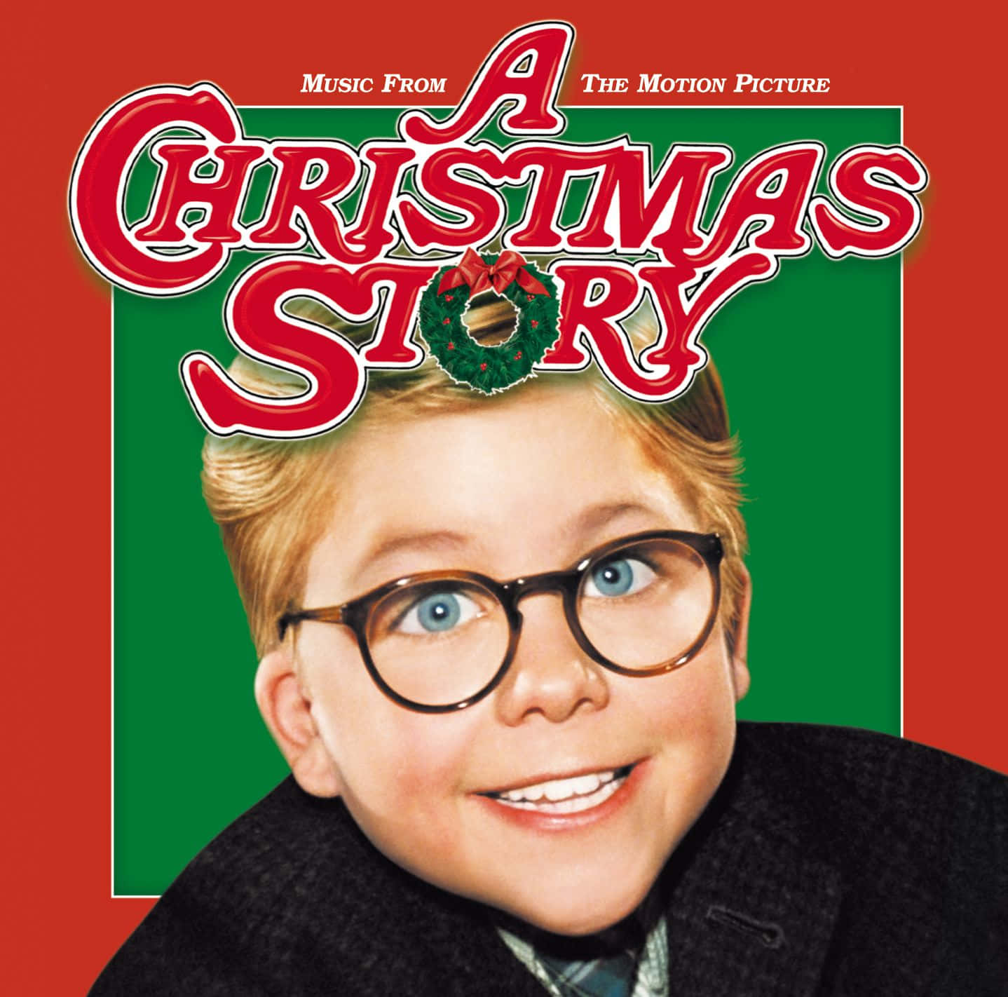 與《A Christmas Story》一起慶祝歡樂聖誕節 壁紙 — 一個戴眼鏡的開朗小男孩，在帶有電影標題的節日紅綠背景前燦爛微笑。