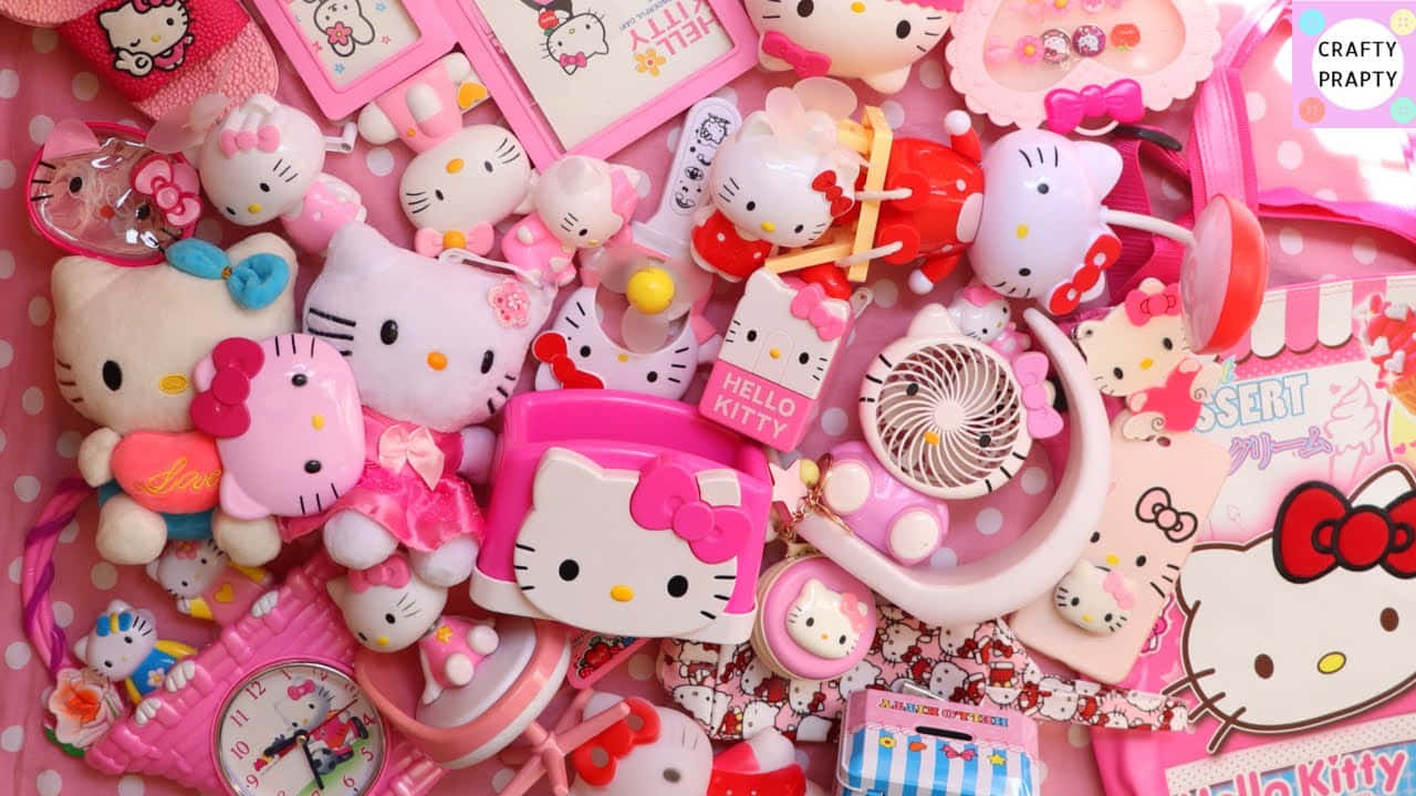 與 Hello Kitty 一同慶祝 壁紙 — 一堆充滿活力的粉紅色Hello Kitty商品，包括毛絨玩具、配件和文具，以俏皮凌亂的方式排列。