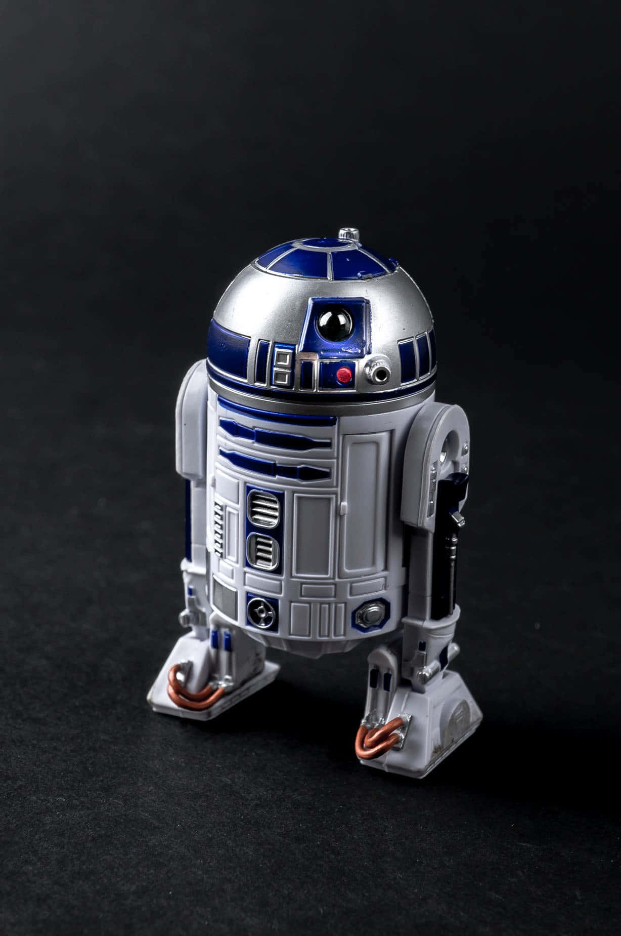 與 R2-D2 探索未知 壁紙 — 一個詳細的R2-D2機械人模型，在深色背景前帶有金屬銀色和藍色點綴。