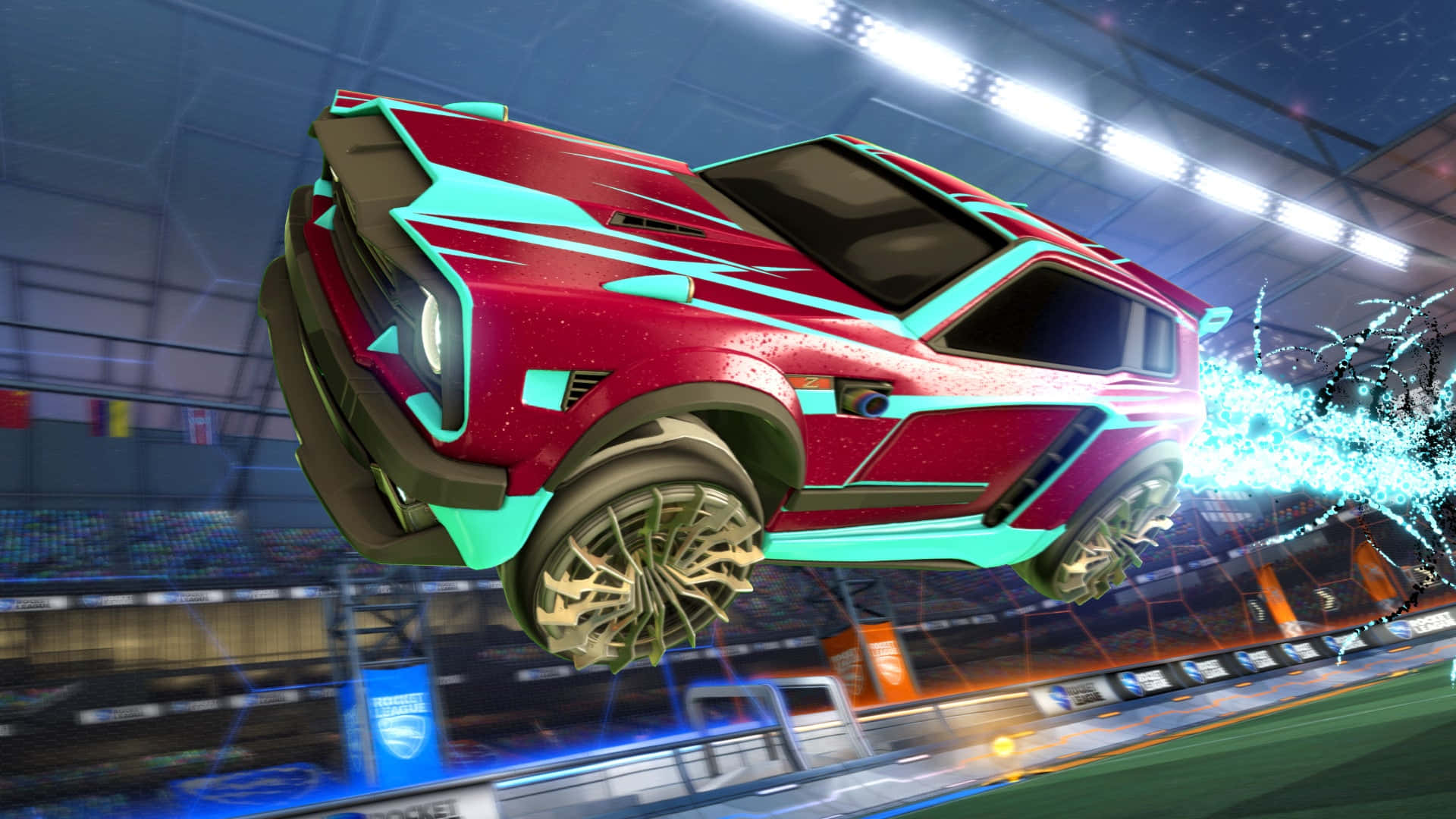 與 Rocket League 一同翱翔天際 壁紙 — 一輛紅色和藍綠色的火箭動力車在體育館中疾馳，留下發光的藍色能量軌跡。