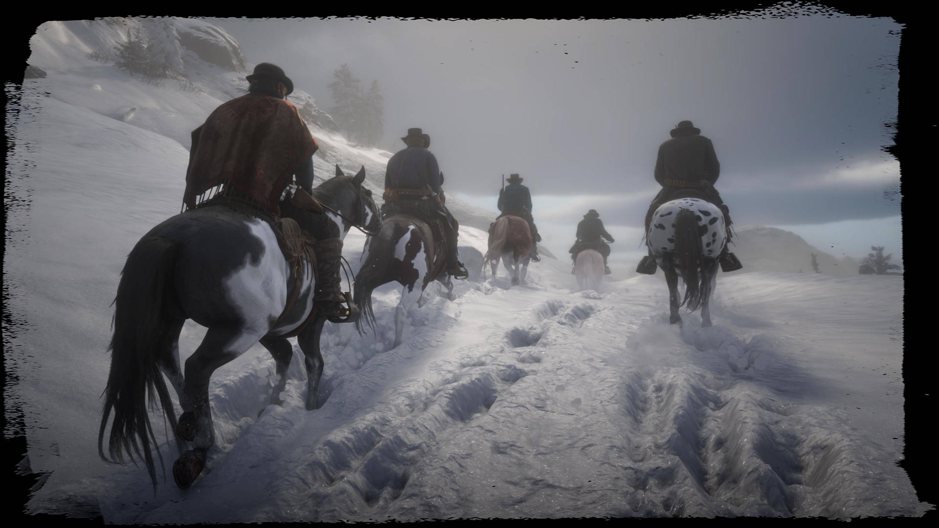 牛仔騎馬在黃昏時分走過積雪的山巒。