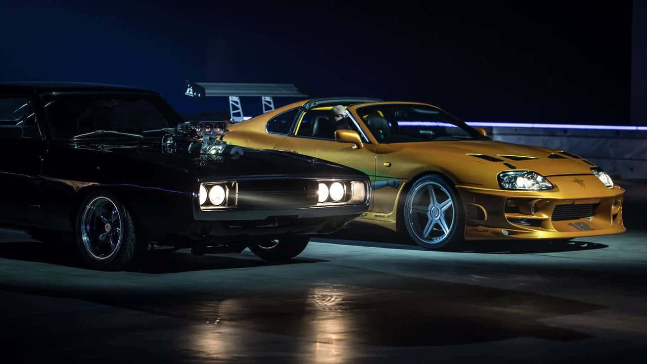 兩輛經典肌肉車，黑色道奇Charger和金色豐田Supra，夜間並排停放，車頭燈亮著。