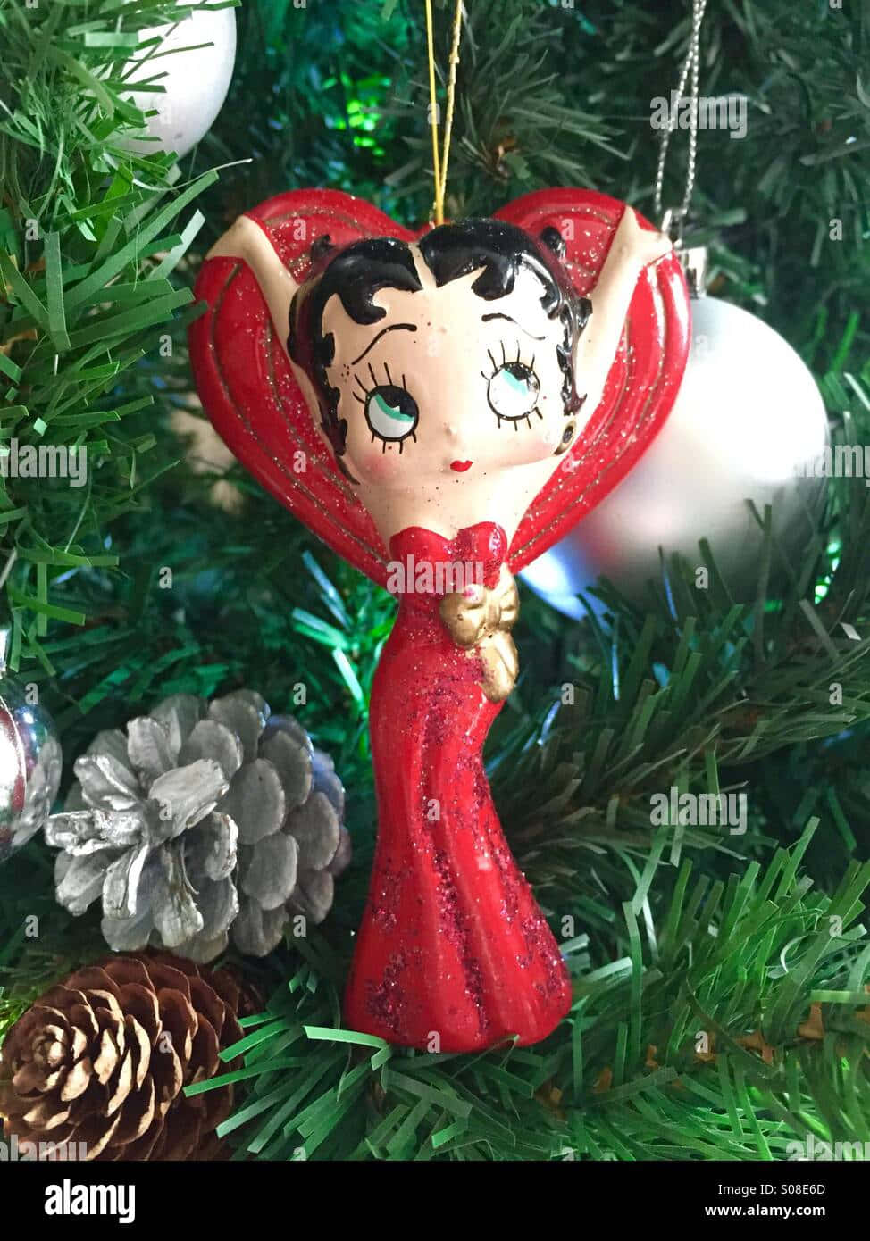 Betty Boop聖誕裝飾品，閃閃發光的紅色裙子，掛在有松果的樹上。