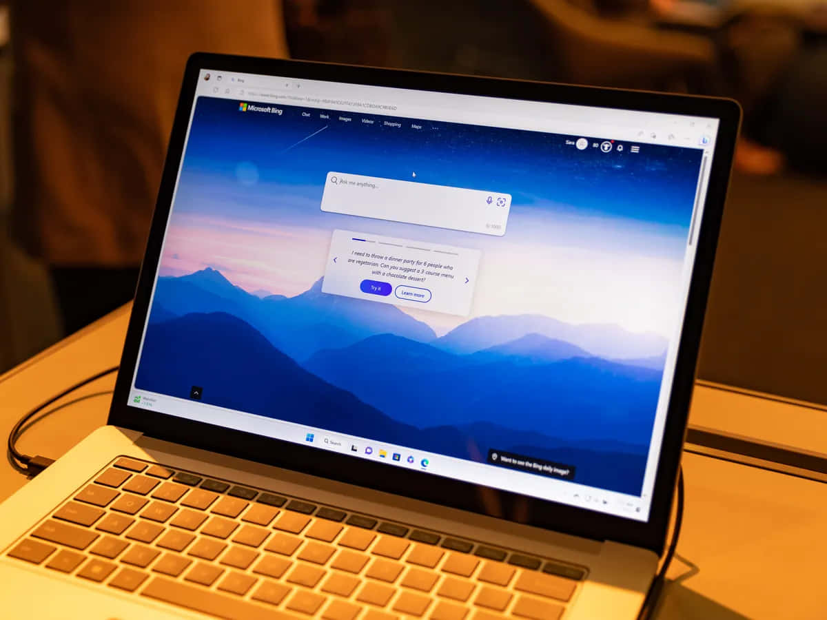 筆記型電腦顯示Microsoft Bing聊天，背景為暮色中的山脈桌布。