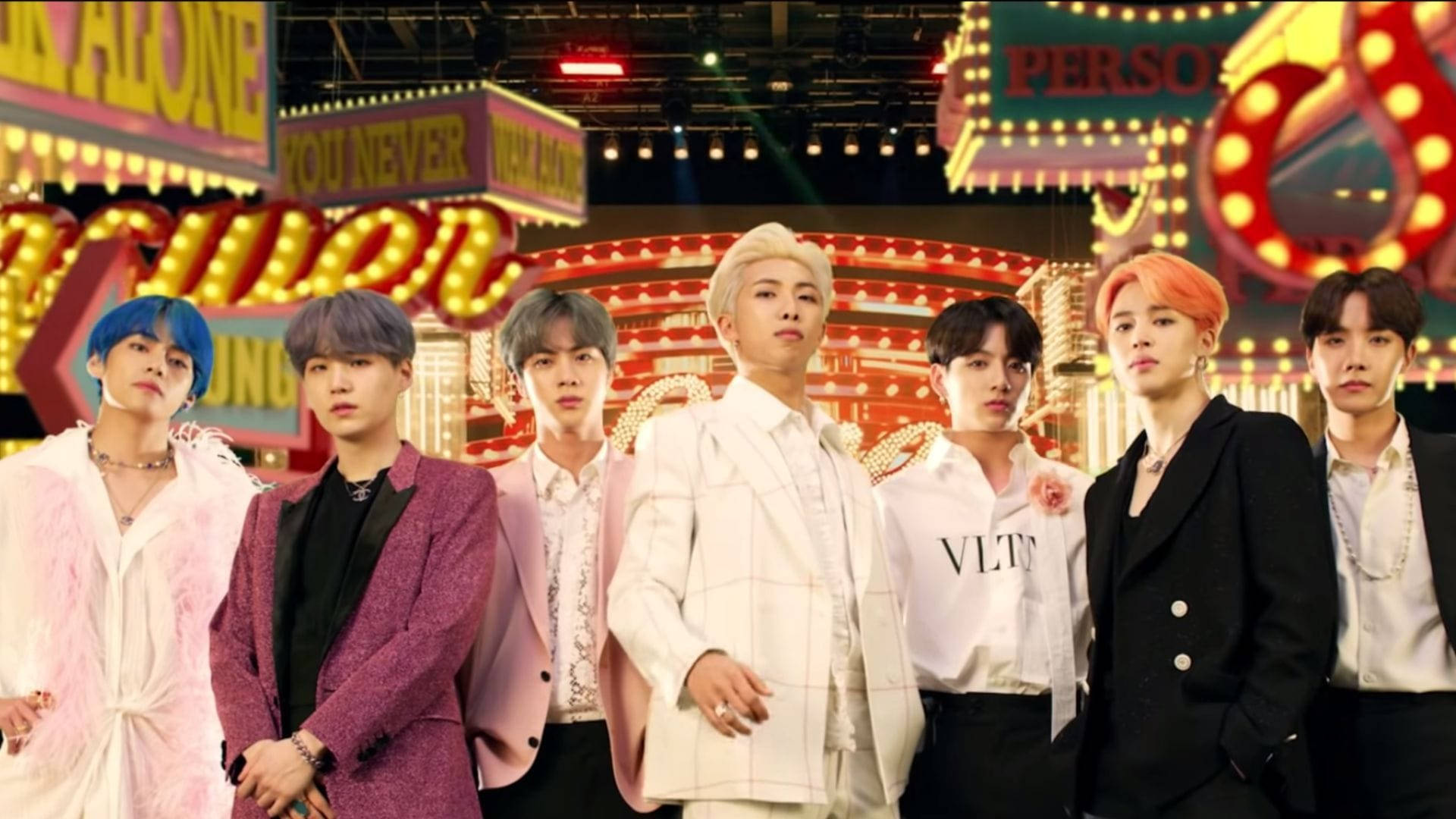 七位K-pop偶像穿著時尚服裝，在霓虹燈照亮嘅賭場舞台上擺姿勢。
