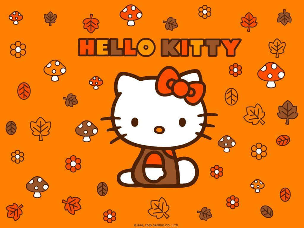 與Hello Kitty一同歡度感恩節 壁紙 — Hello Kitty 微笑著坐在一個充滿活力的橙色田野中，散落著秋天的樹葉、蘑菇和花朵。