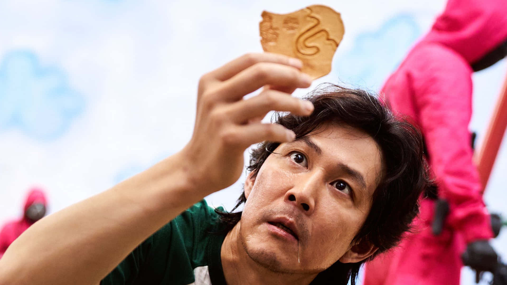 男子手持木製魷魚代幣，水滴從下巴滴落戶外。