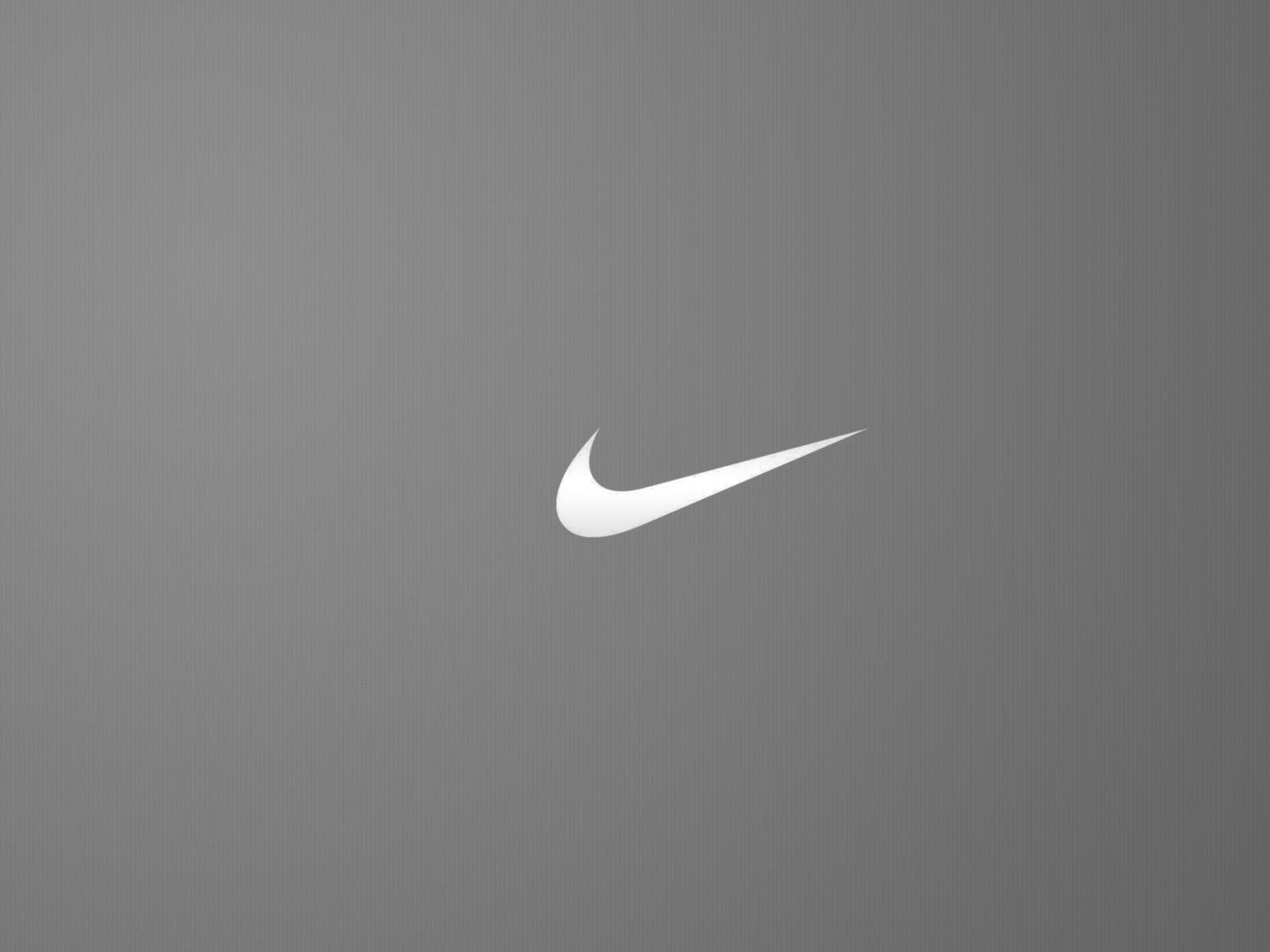 白色Nike swoosh標誌在灰色紋理背景上。