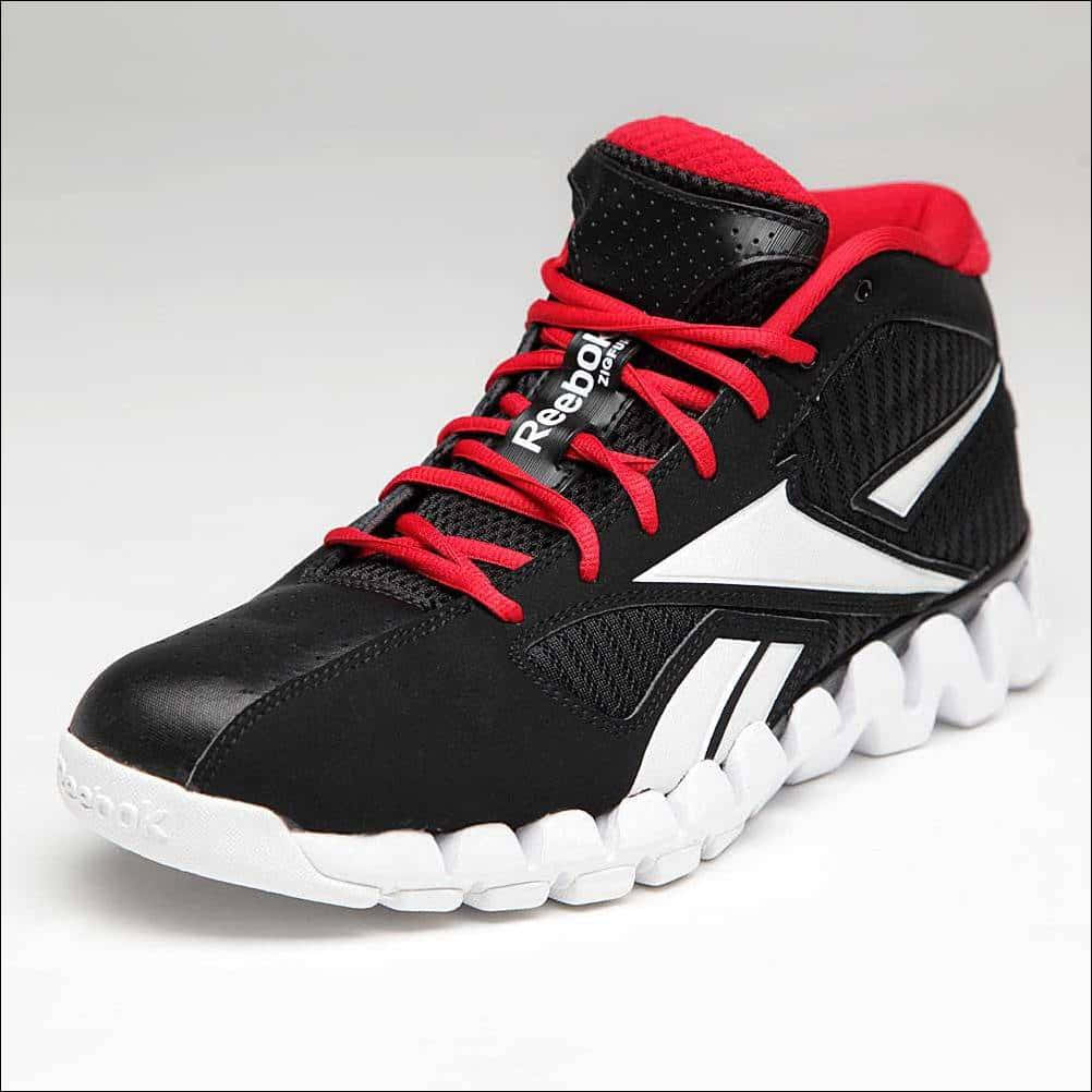 與Reebok一起動起來 壁紙 — 一對黑色 Reebok 高筒運動鞋，紅色鞋帶，白色鞋底，純白背景。