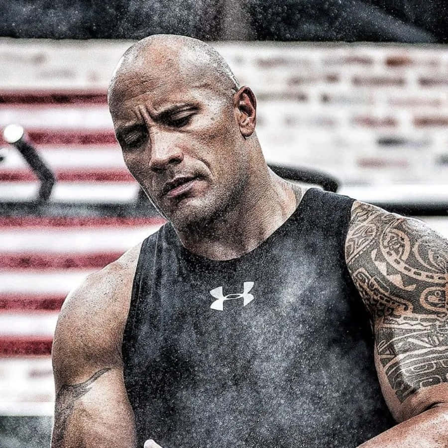 一個在健身房穿著 Under Armour 背心、汗流浹背的紋身男子。
