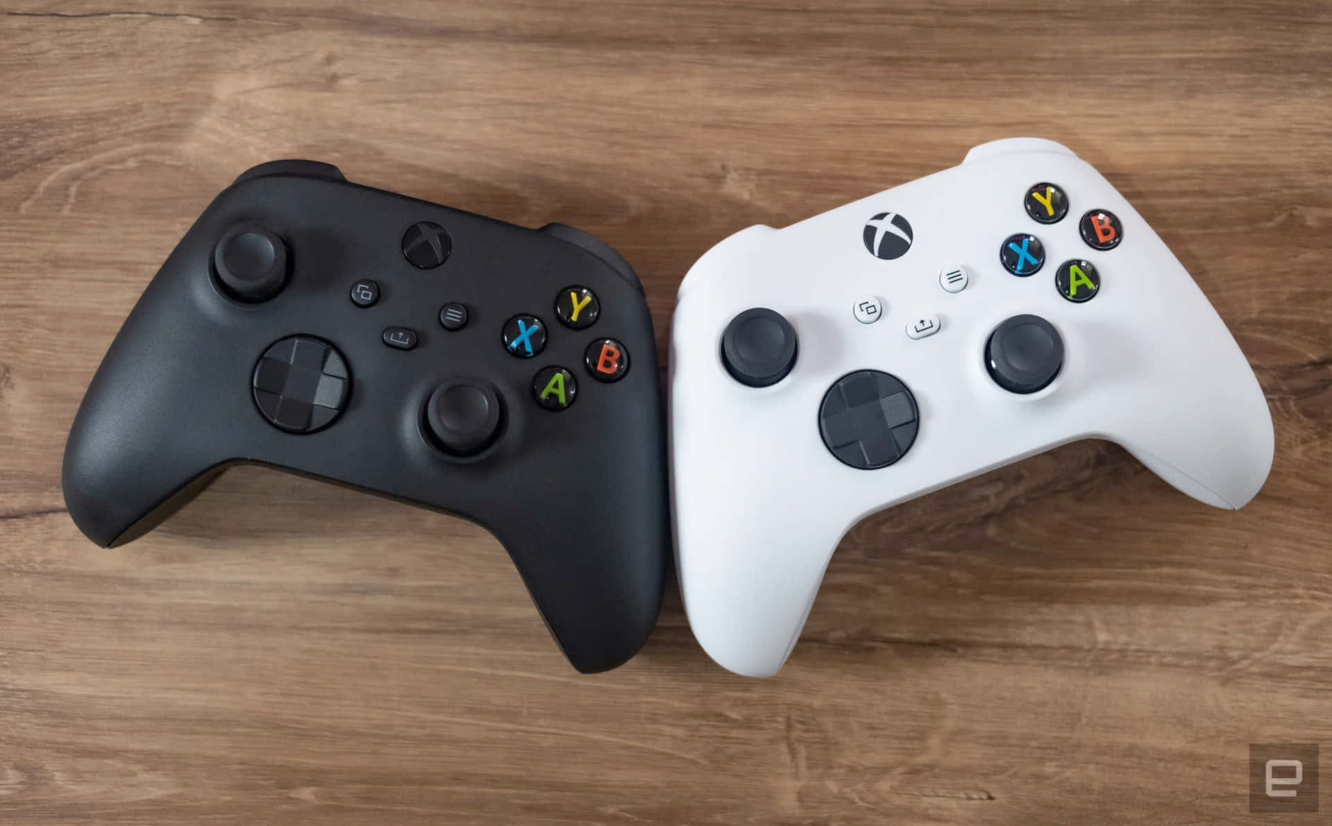 木桌上黑白Xbox手掣