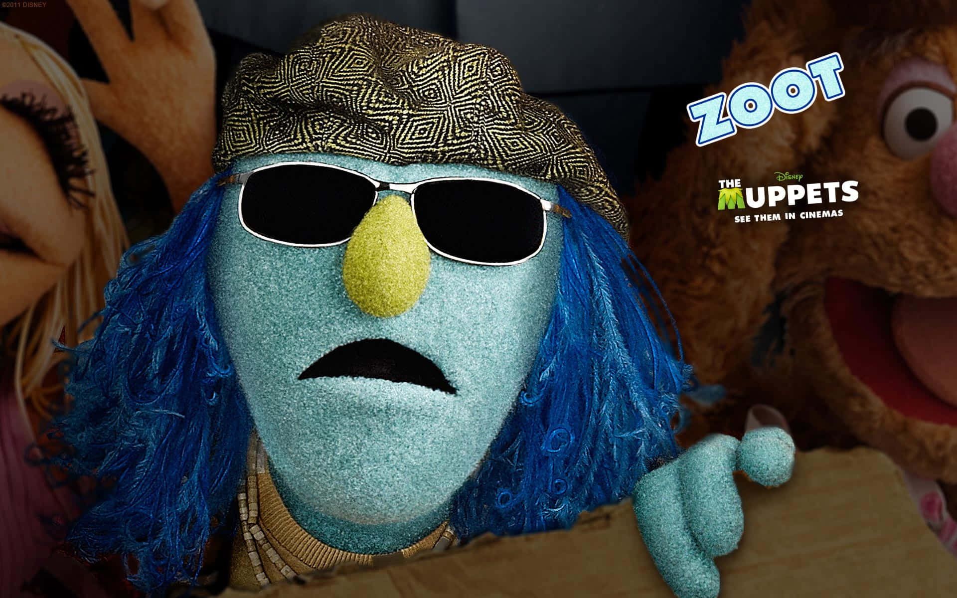 藍色Muppet戴着太陽眼鏡和帽子，與其他Muppet一起出現在電影宣傳中。