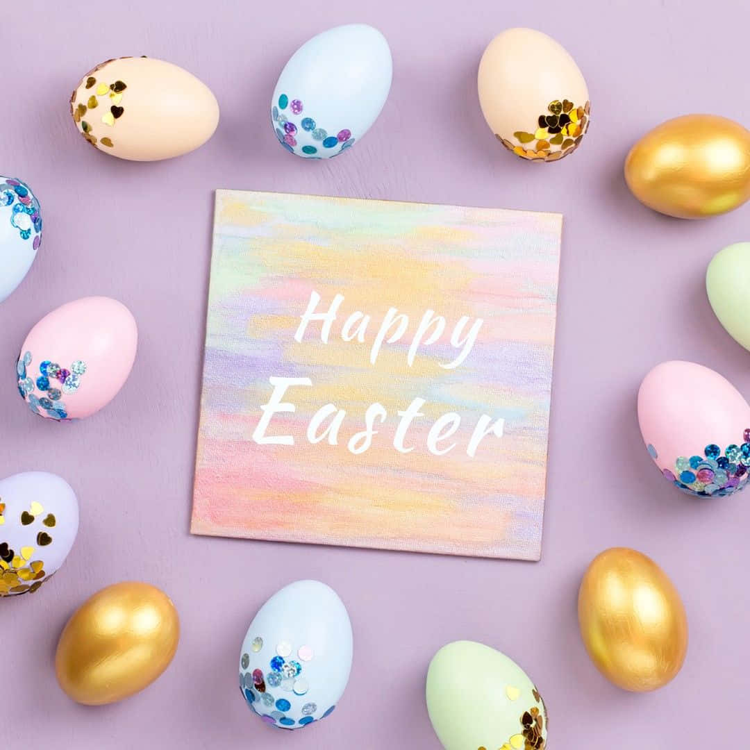 與家人朋友共慶快樂復活節 壁紙 — 粉彩和金色復活節蛋配閃粉圍繞著一個「Happy Easter」畫布，放在柔軟的紫色表面上。