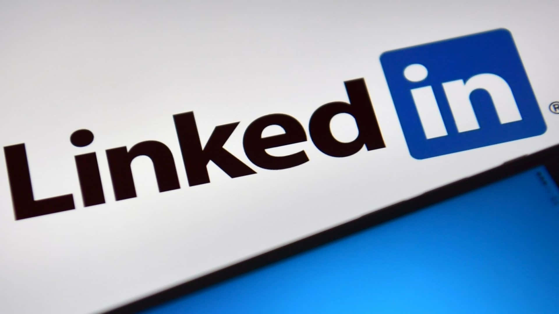 與專業人士建立聯繫與網絡 壁紙 — 屏幕上LinkedIn標誌的特寫，背景為藍色漸變。