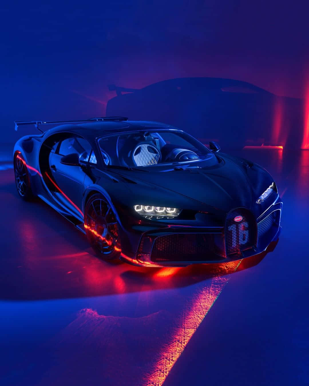 黑色Bugatti Chiron Super Sport在迷霧工作室中被藍色和紅色霓虹燈照亮。