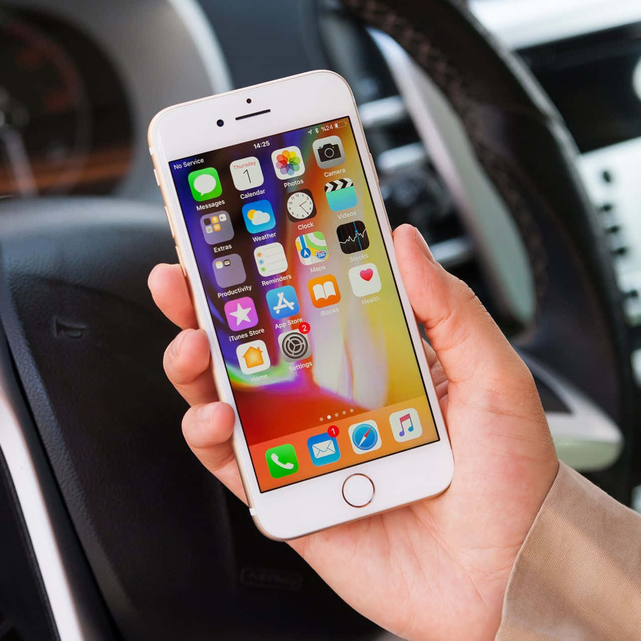 手在車內拿著iPhone顯示應用程式圖標