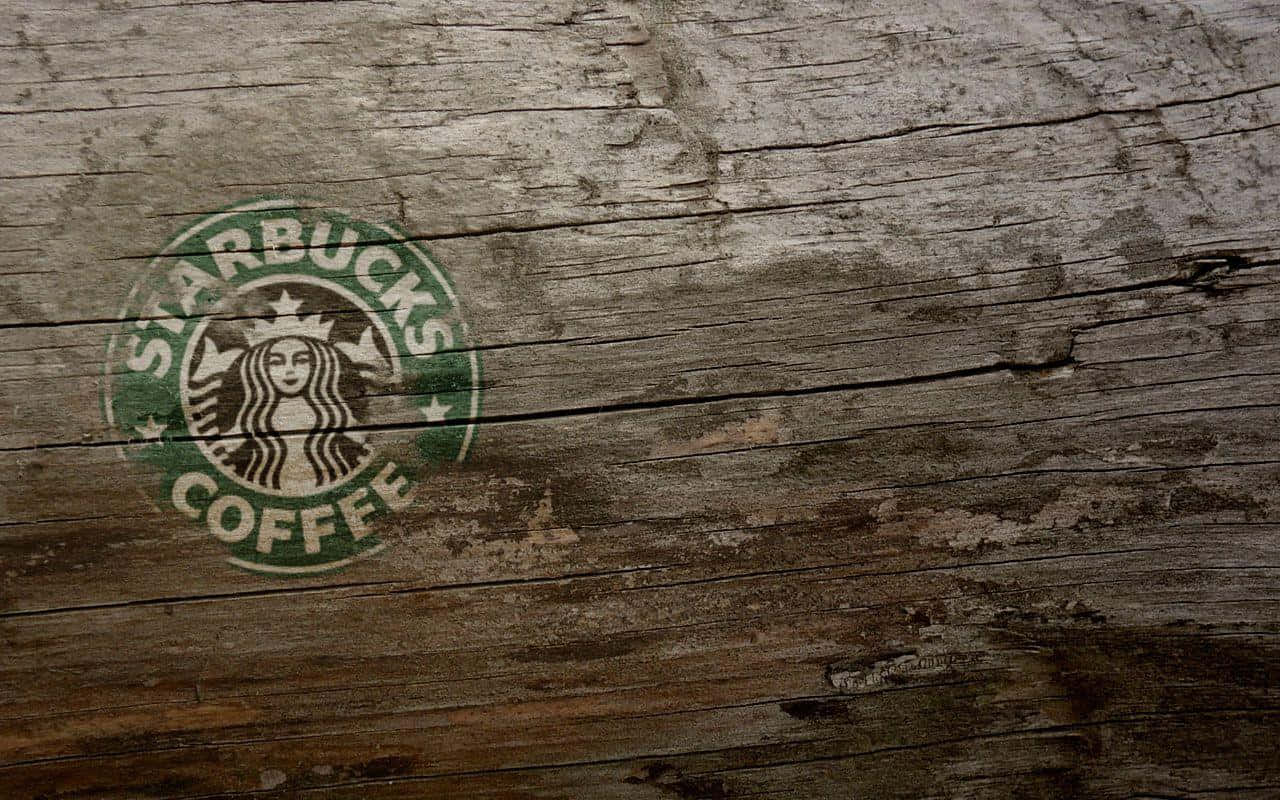 Starbucks咖啡標誌塗在風化的木質表面上。