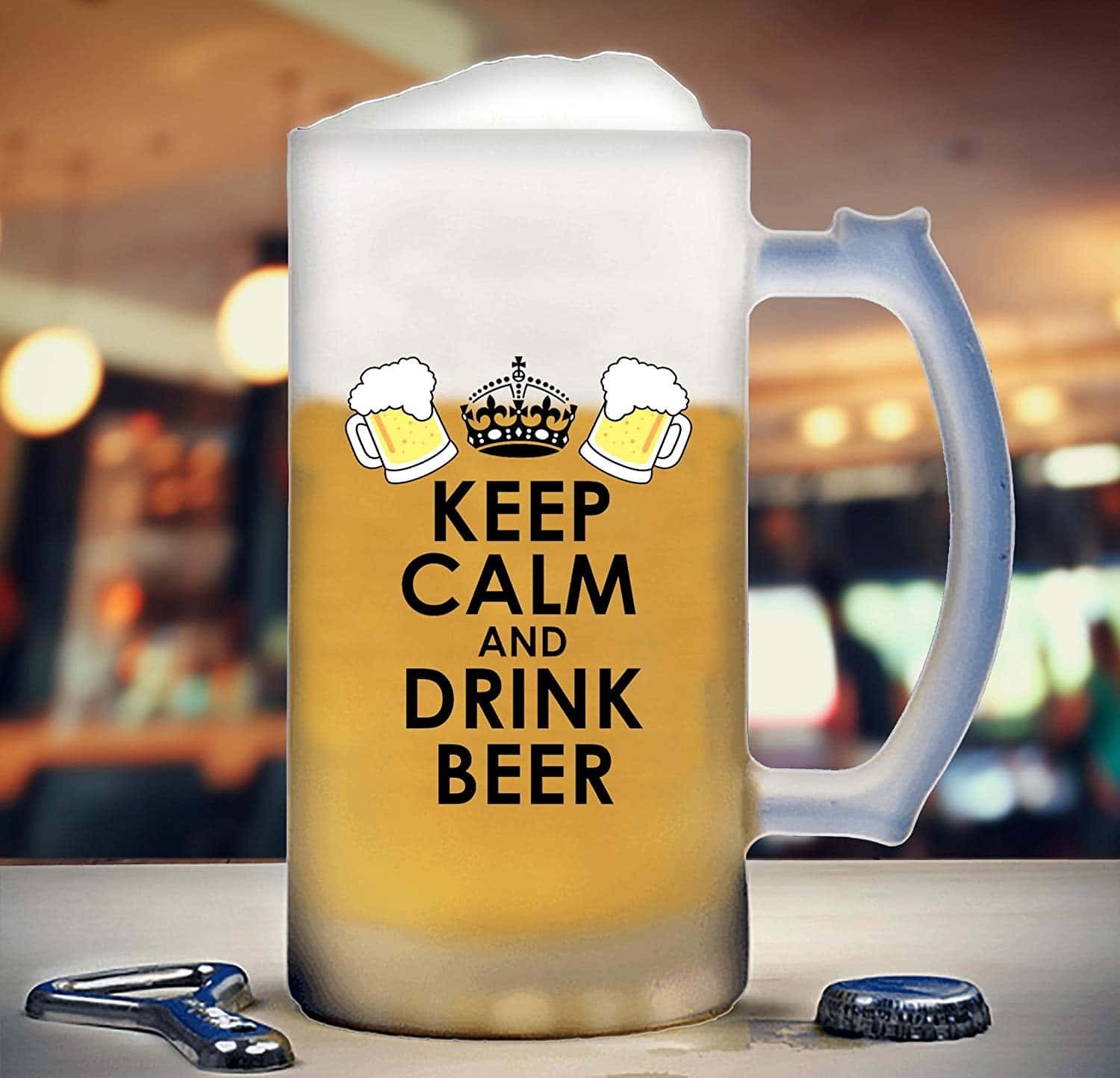 與朋友共享新釀啤酒 壁紙 — 一個結霜的啤酒杯，上面有「Keep Calm and Drink Beer」文字和皇冠圖案，放在吧檯上，附近有開瓶器和瓶蓋。