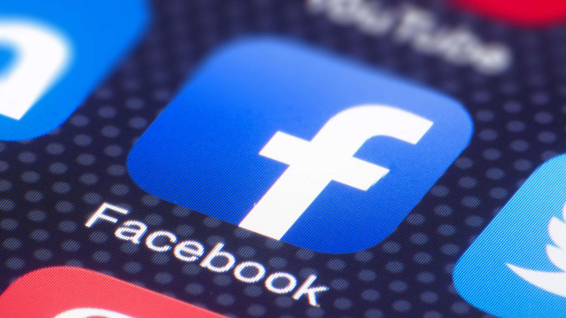 智能手機屏幕上的Facebook應用程式圖標，背景中其他社交媒體應用程式模糊。