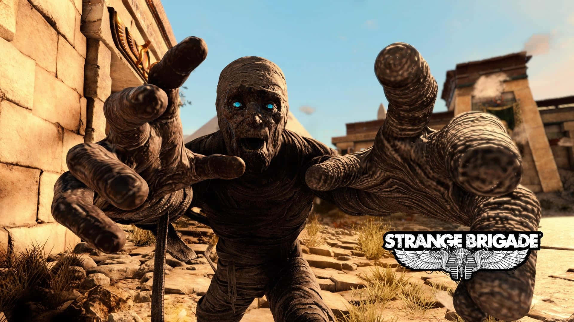 與木乃伊惡徒展開驚險戰鬥《Strange Brigade》 壁紙 — 一個帶有發光藍色眼睛的威脅性木乃伊在明亮的日光下，於古埃及廢墟中向前猛撲。