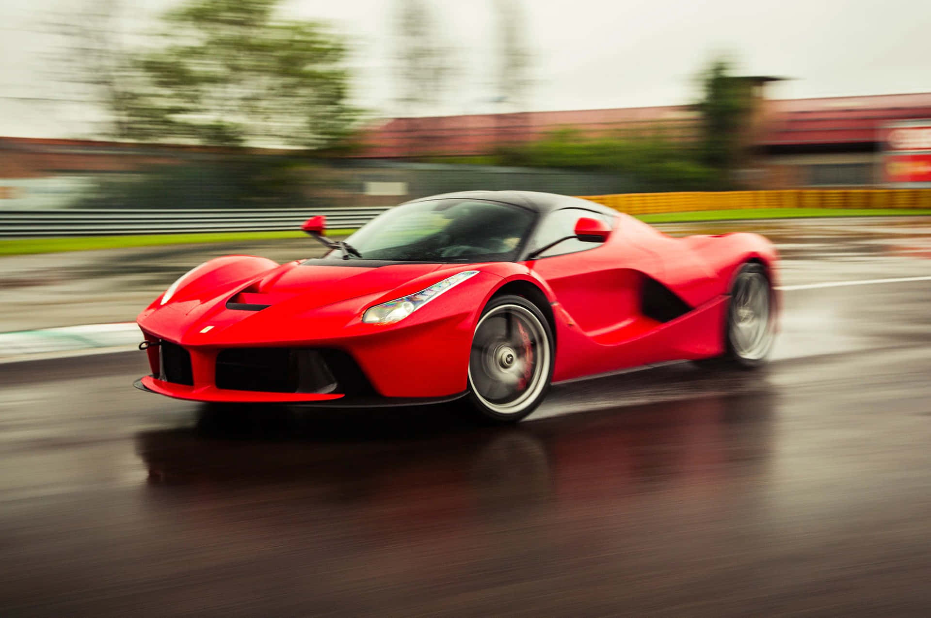 紅色法拉利 LaFerrari 在潮濕賽道上高速行駛，帶動態模糊。
