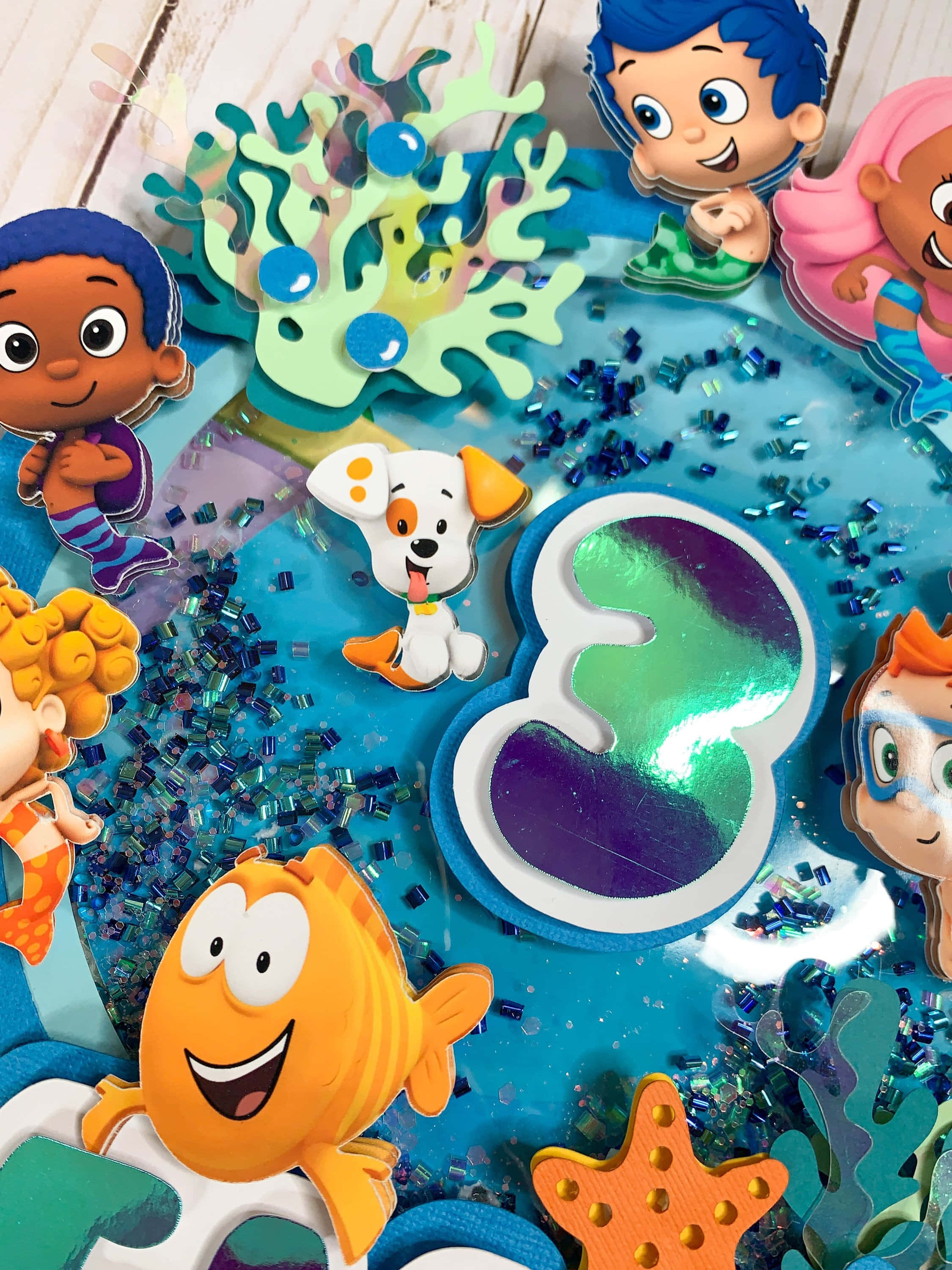 「與泡泡小鯉魚一起探索與發現！」 壁紙 — 來自 Bubble Guppies 和 PAW Patrol 的彩色卡通角色漂浮在閃閃發光的藍色海洋場景中，有珊瑚和數字三。