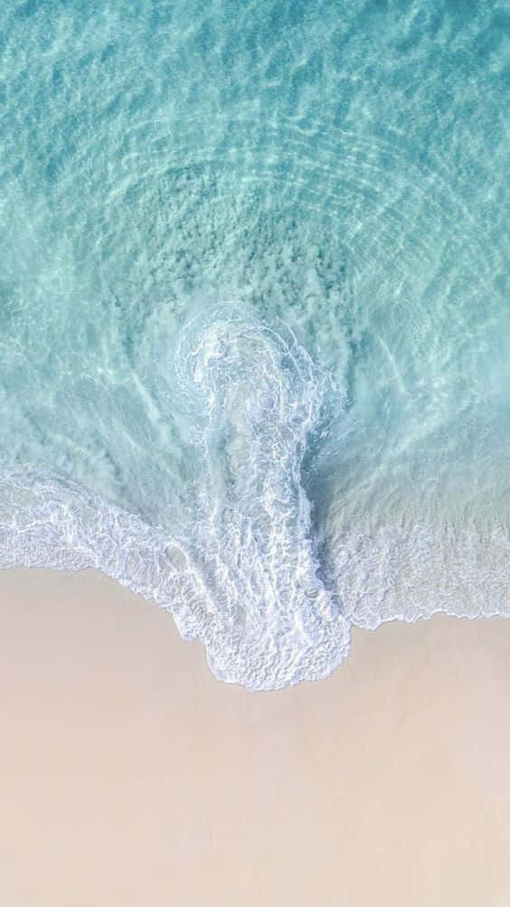 與波浪道別，揮別審美壓力 壁紙 — 從高空俯瞰，碧綠的海浪輕輕捲上淡色沙灘。