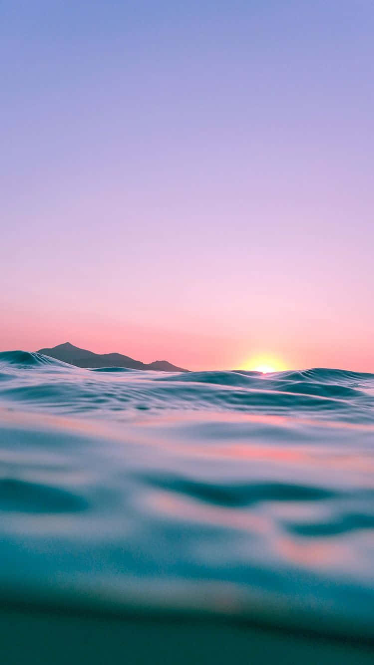 夕陽下的海洋，山巒剪影和寧靜的波浪