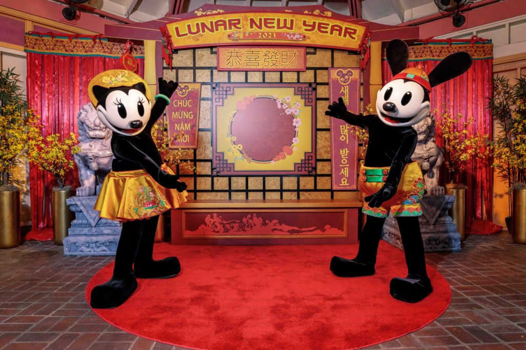 米奇和米妮穿著農曆新年服裝在紅地毯上擺姿勢。