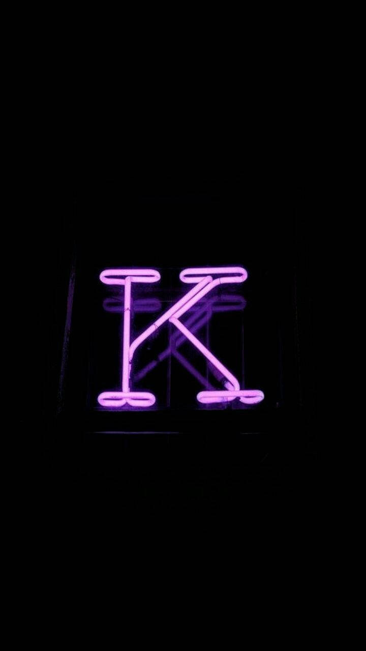 在黑暗中發光並帶有反光的紫色霓虹字母K。