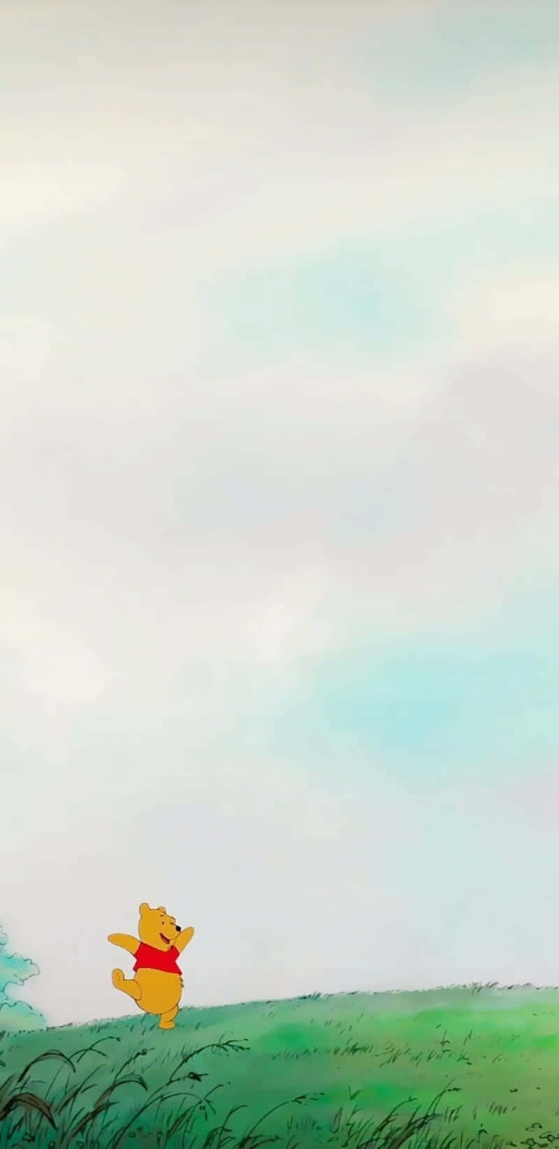 小熊維尼在柔和天空下的草丘上