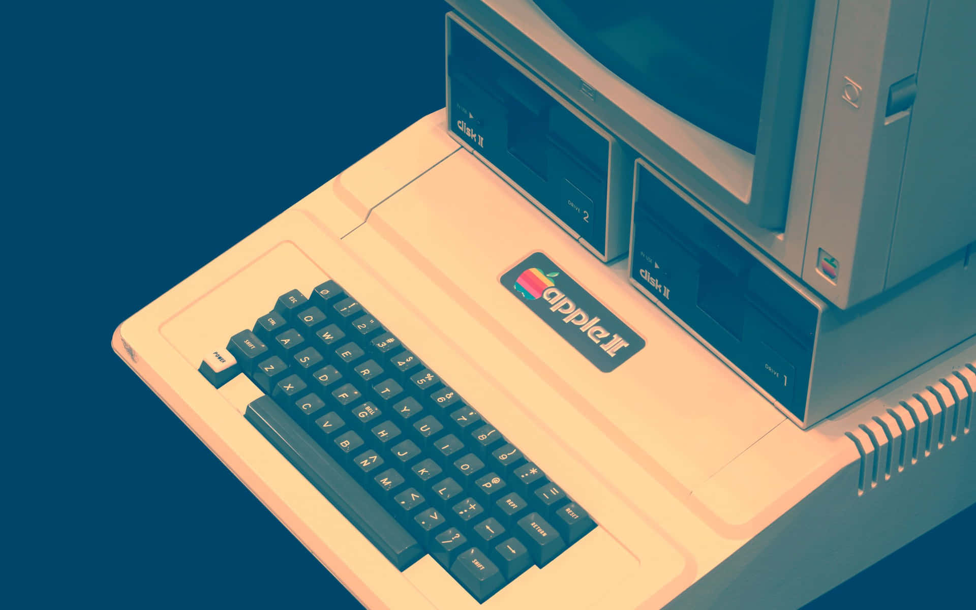 復古Apple II電腦，米色外殼和深色鍵盤，藍色背景。