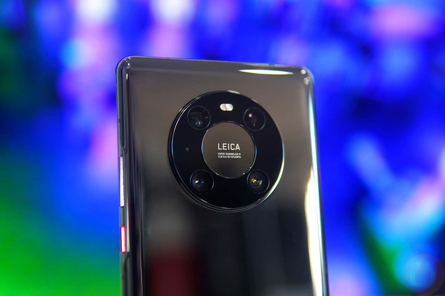 黑色智能手機帶有 Leica 相機模組，背景為彩色模糊效果。