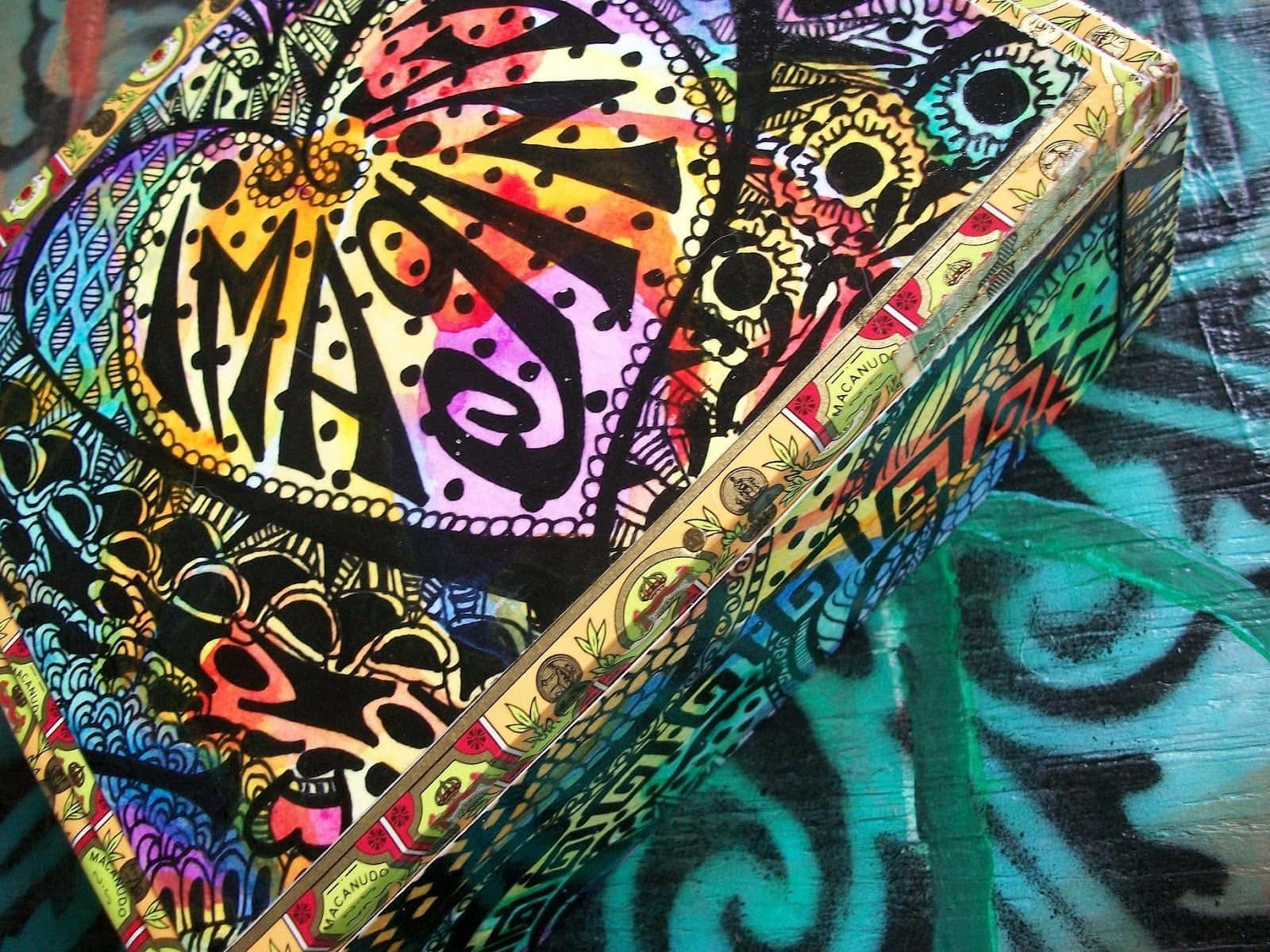 一個裝飾盒子，帶有彩色迷幻圖案，放置在相配的表面上。