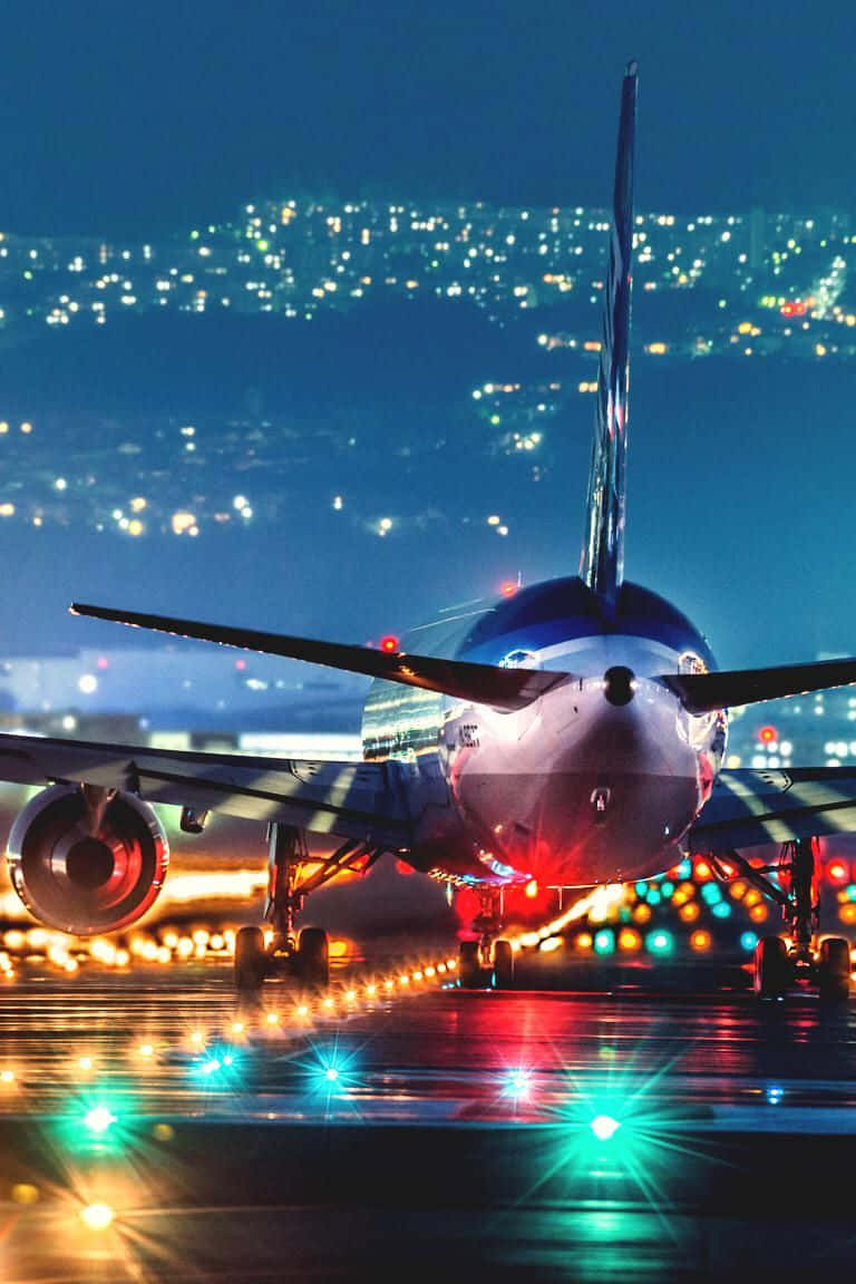 夜間一架大型飛機停在濕滑的跑道上，背景是城市燈光閃爍。