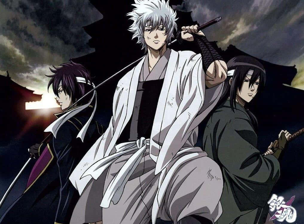「與銀魂一起，享受全新經典！」 壁紙 — 三名動畫武士手持刀劍，在暴風雨黃昏的天空下，矗立於傳統日本建築的剪影之上。