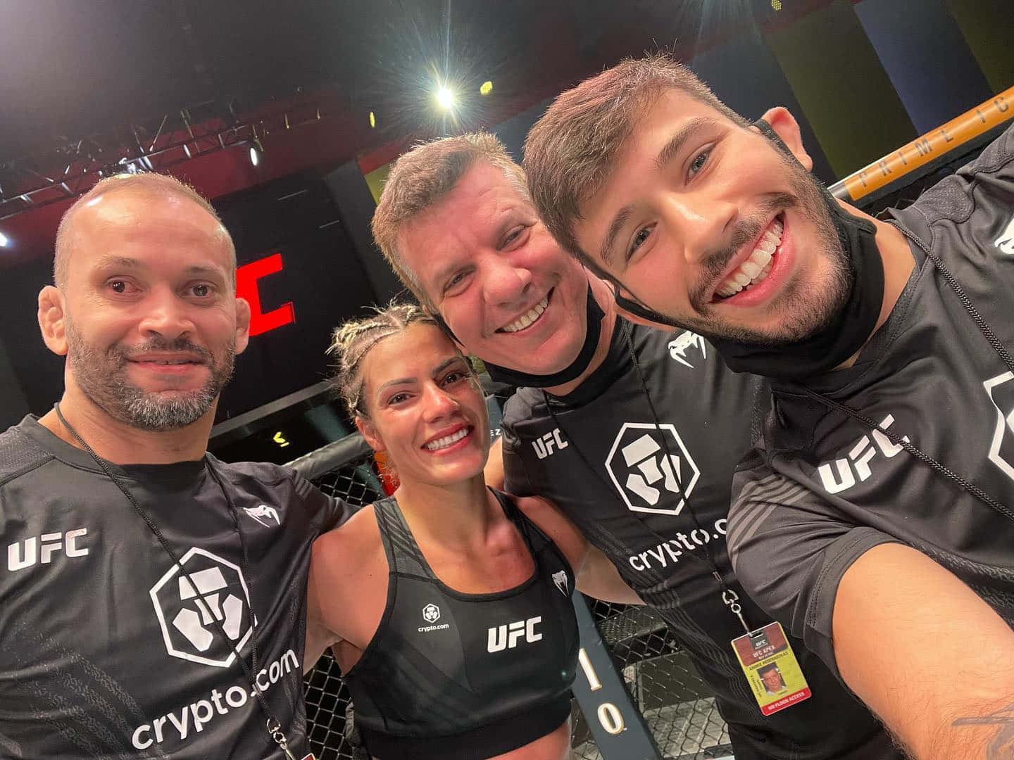 四位UFC拳手及工作人員在八角籠內微笑。