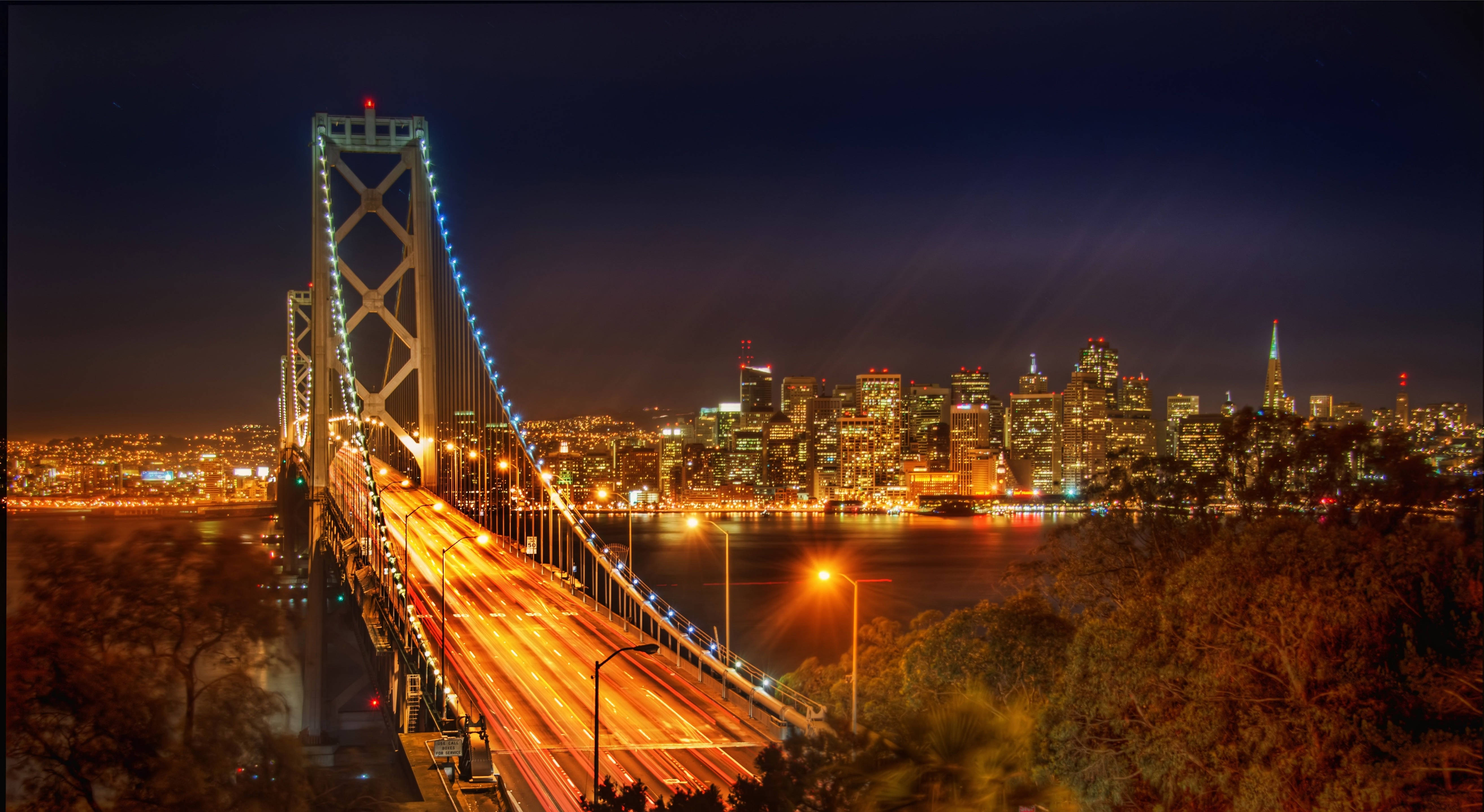海灣大橋夜景，閃爍的城市燈光和流動的車流。