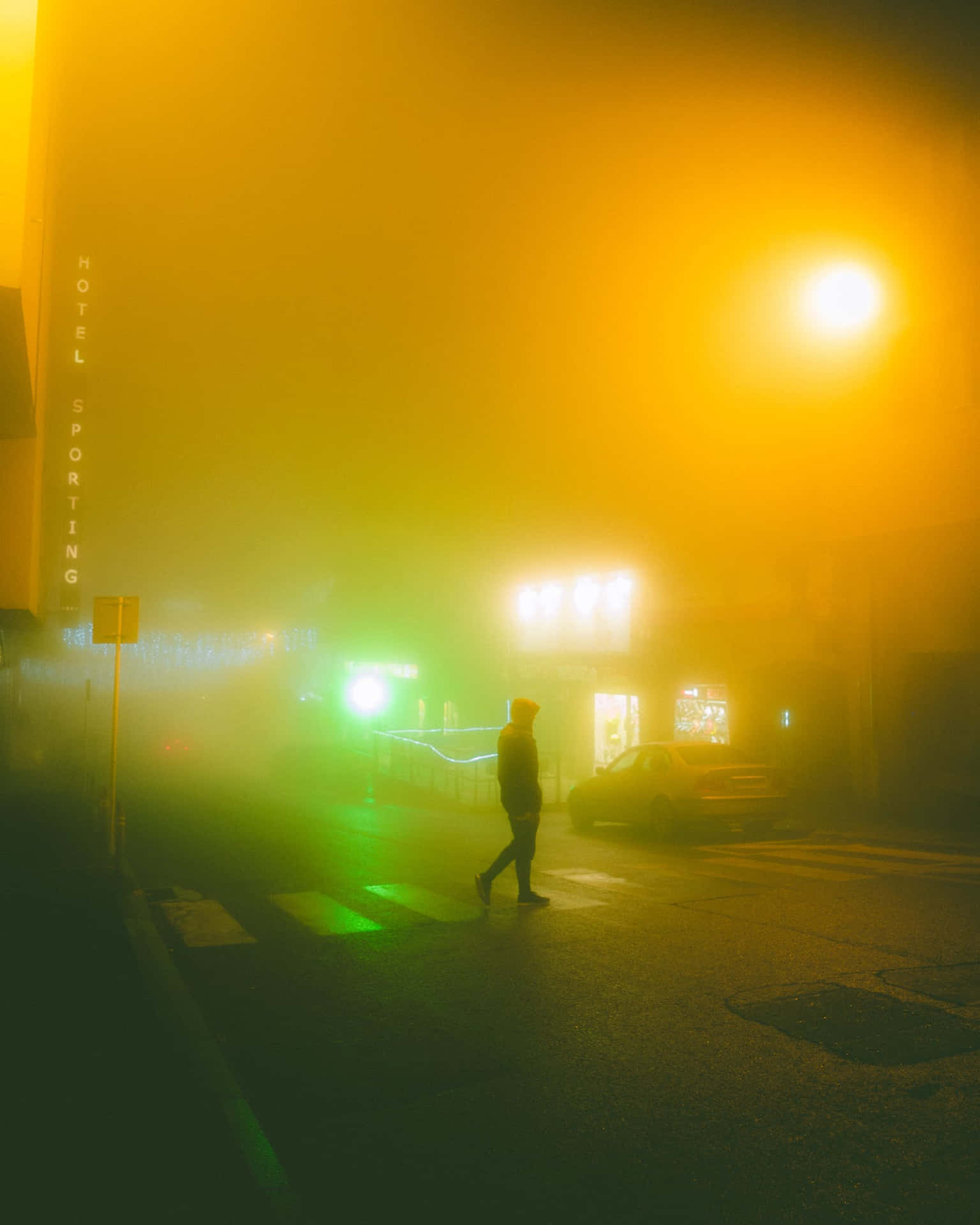 夜晚一個人在霧氣瀰漫的霓虹城市街道上行走。