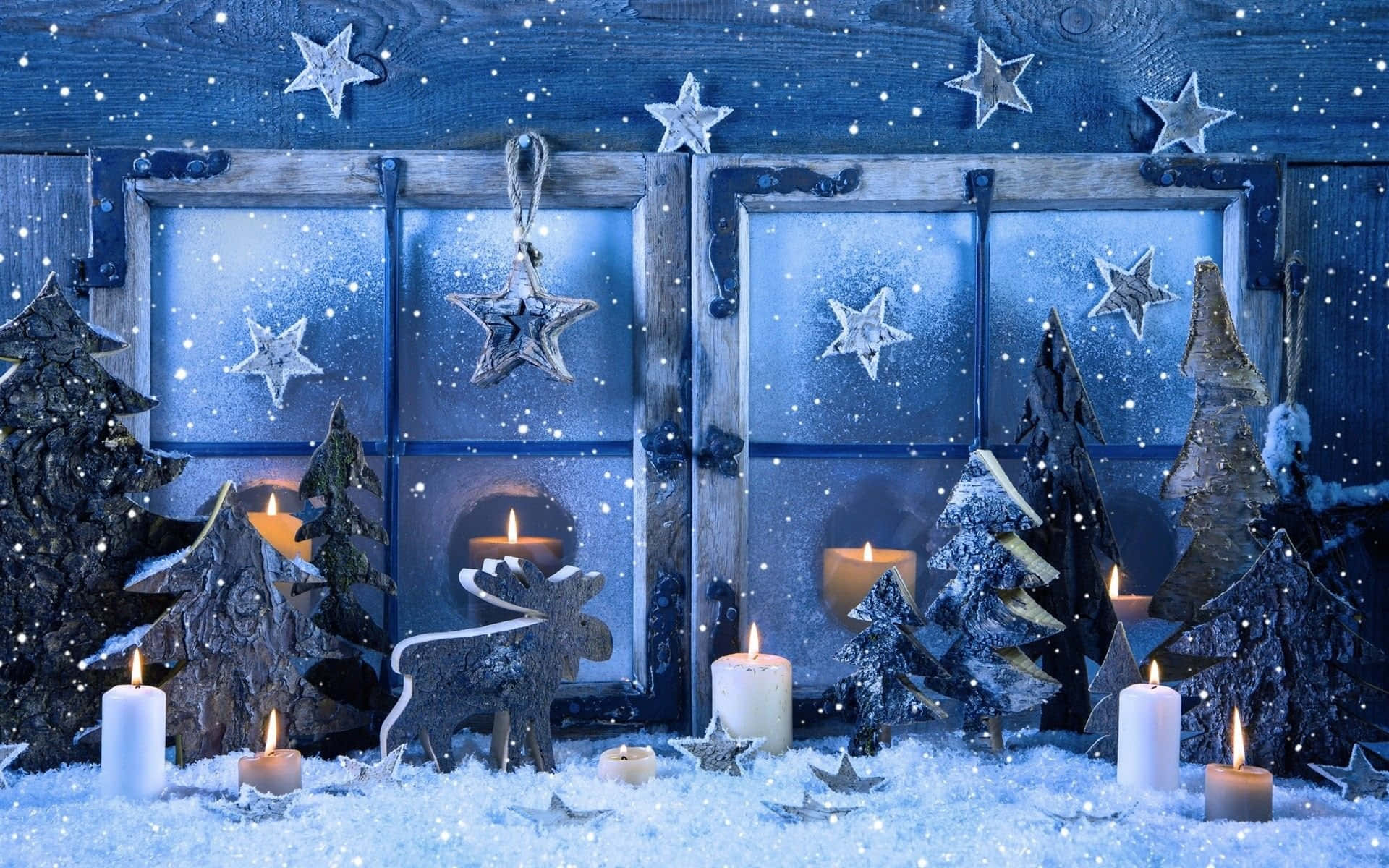 Winter Christmas 桌布 壁紙 — 舒適的冬日場景，雪覆蓋的木製窗框裝飾著星星和點燃的蠟燭，周圍環繞著微型雪樹和馴鹿剪影。