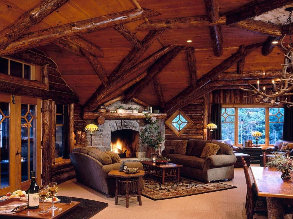 Cozy Winter Cabin 桌布 壁紙 — 舒適的鄉村木屋客廳，石頭壁爐在裸露的木樑下溫暖地發光。