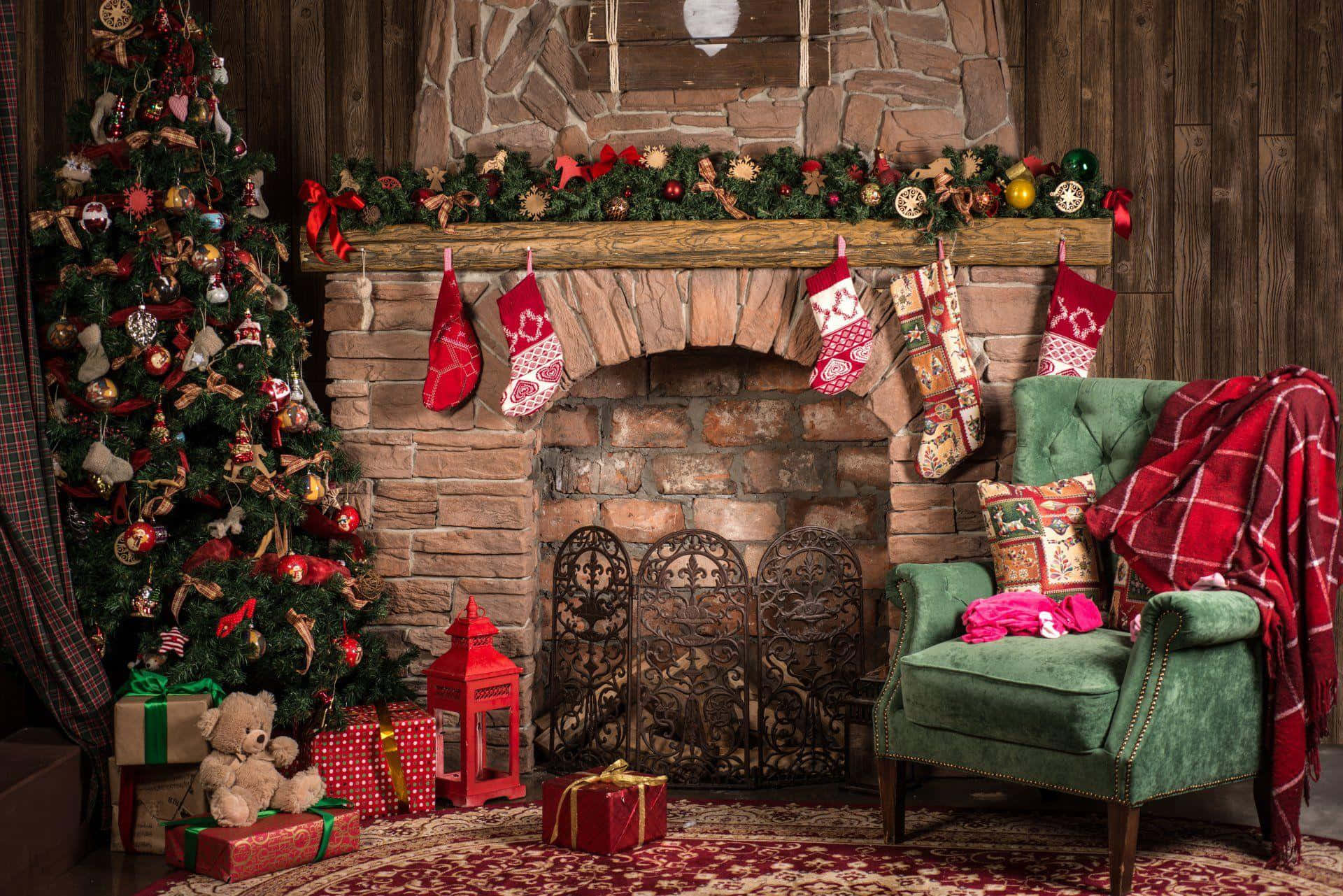 Rustic Christmas 桌布 壁紙 — 舒適鄉村風格客廳，配有石壁爐、聖誕襪、聖誕樹、禮物和鋪上紅色格仔布的綠色扶手椅。