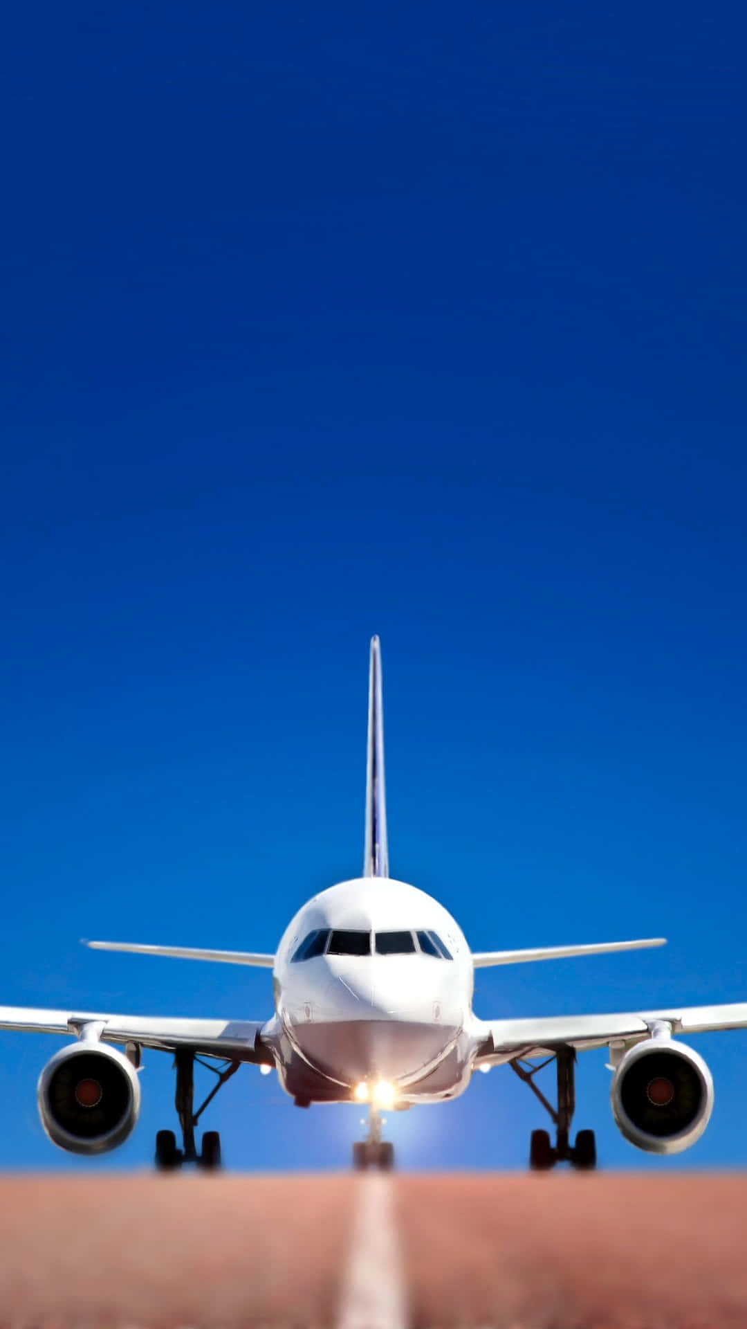 航空冒險 壁紙 — 一架白色客機在晴朗的藍天下接近跑道，降落燈閃爍著光芒。