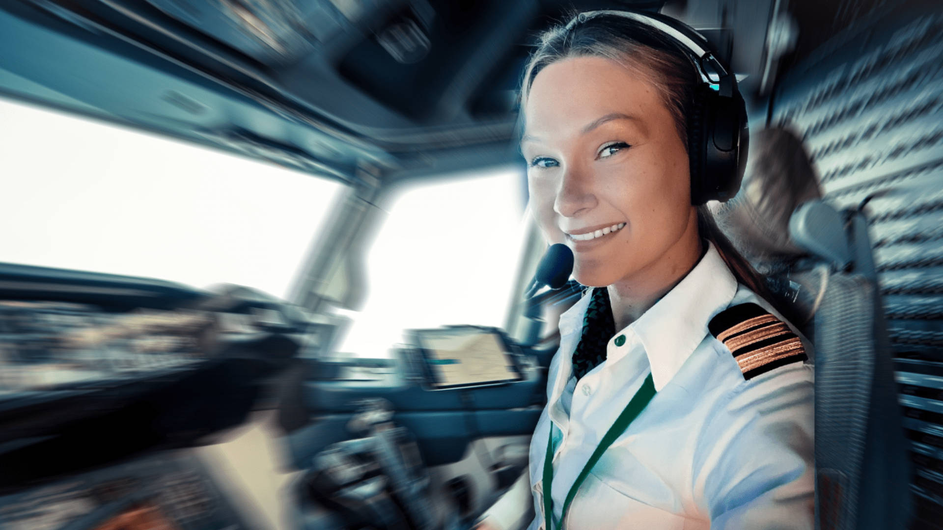 女機師在飛機駕駛艙內戴著耳機和制服微笑。