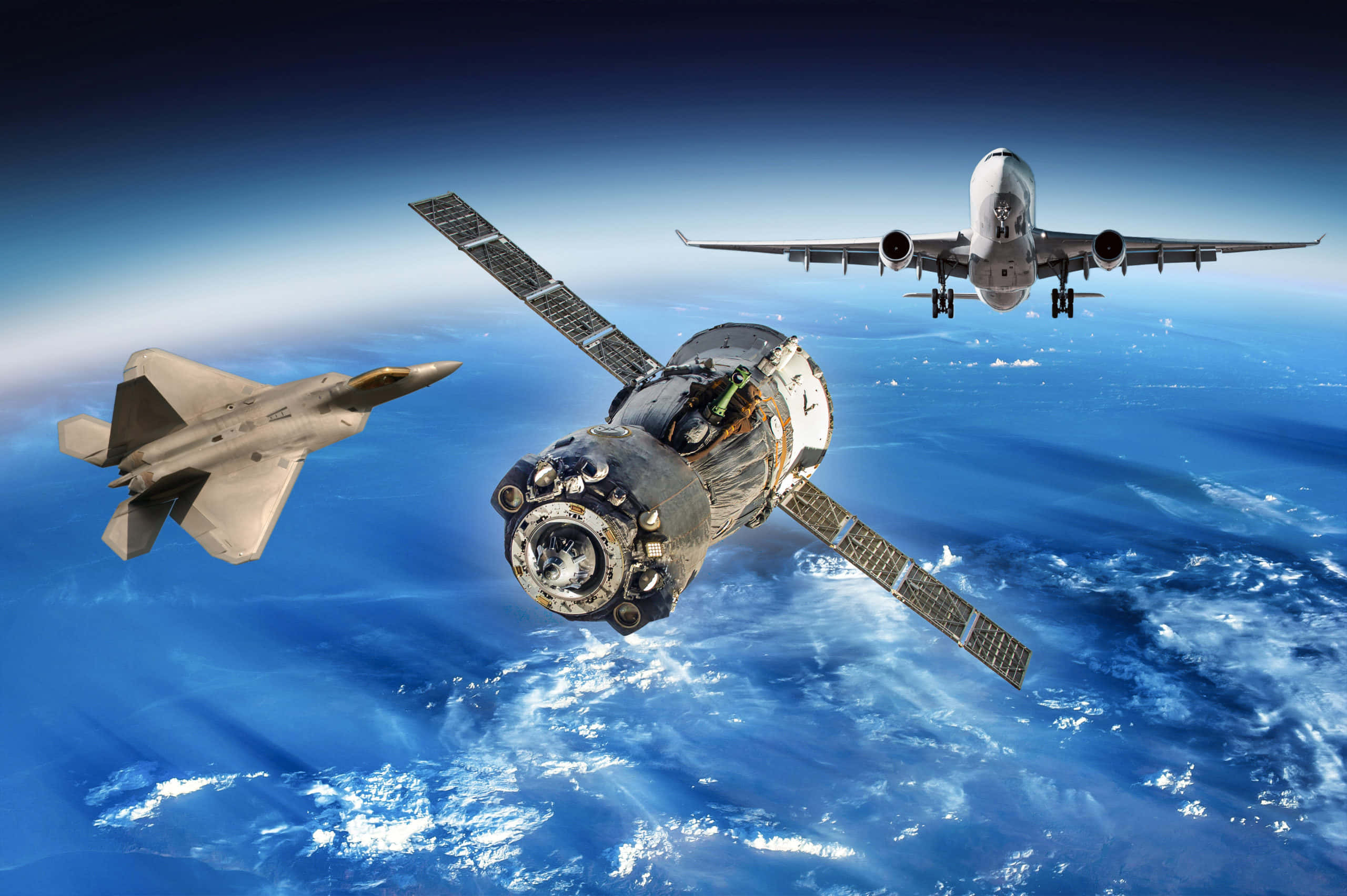 航空航天廠的空中鳥瞰圖 壁紙 — 一架戰鬥機、太空站和客機從軌道上翱翔於地球的藍色海洋和雲層之上。